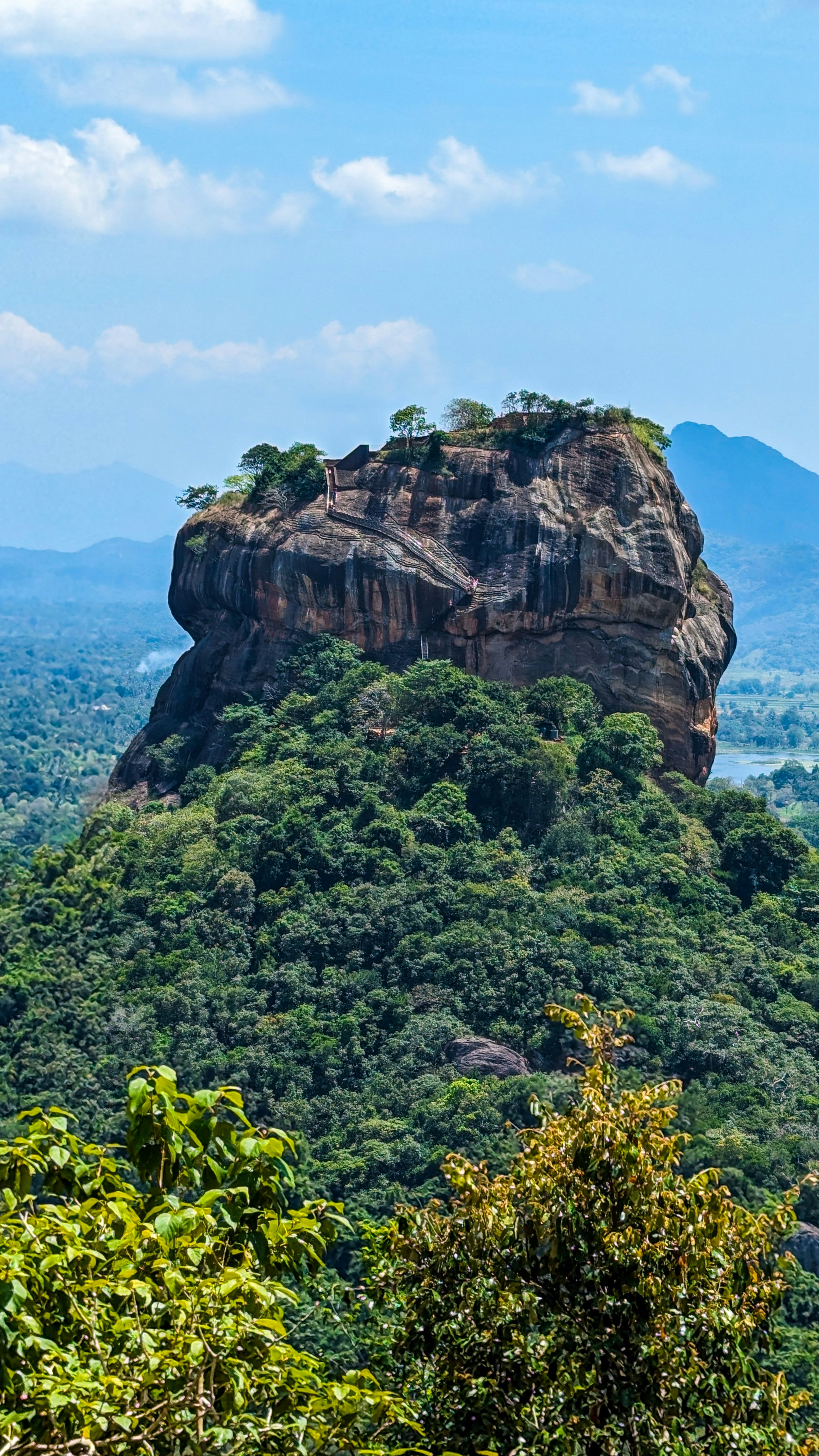 A view of a mountain with trees and mountains in the background