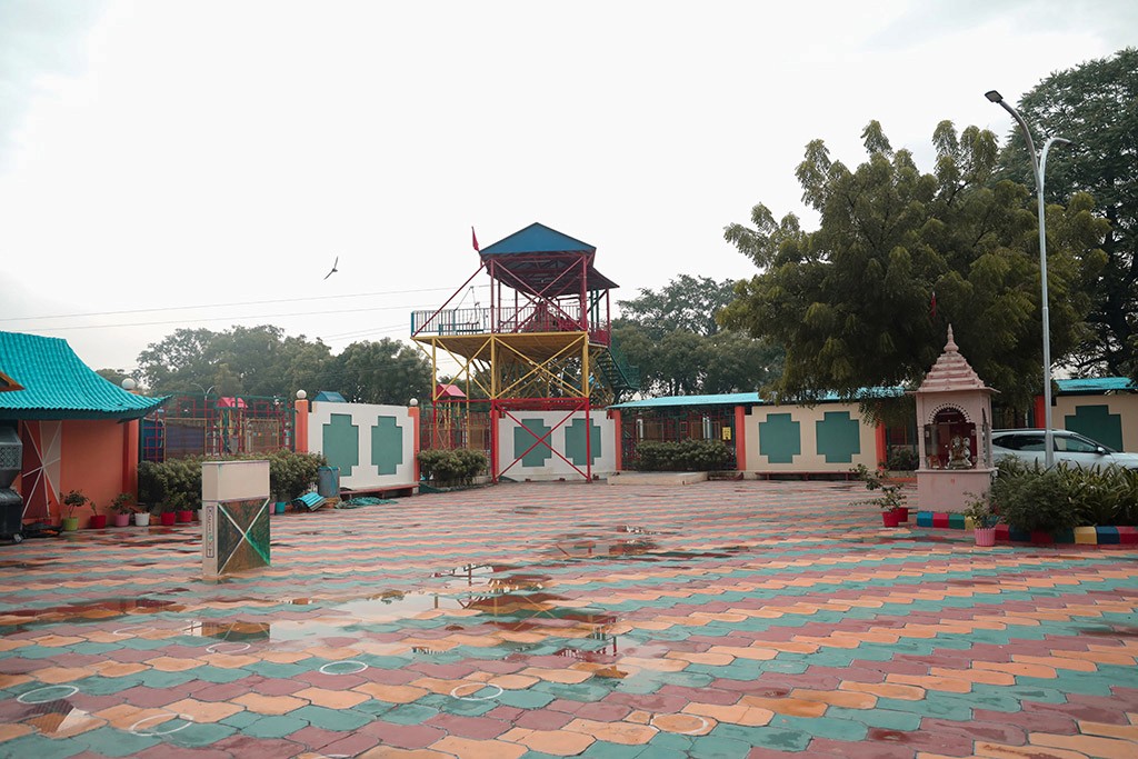 Cozy orange velvet lounge chair by glowing lamp.