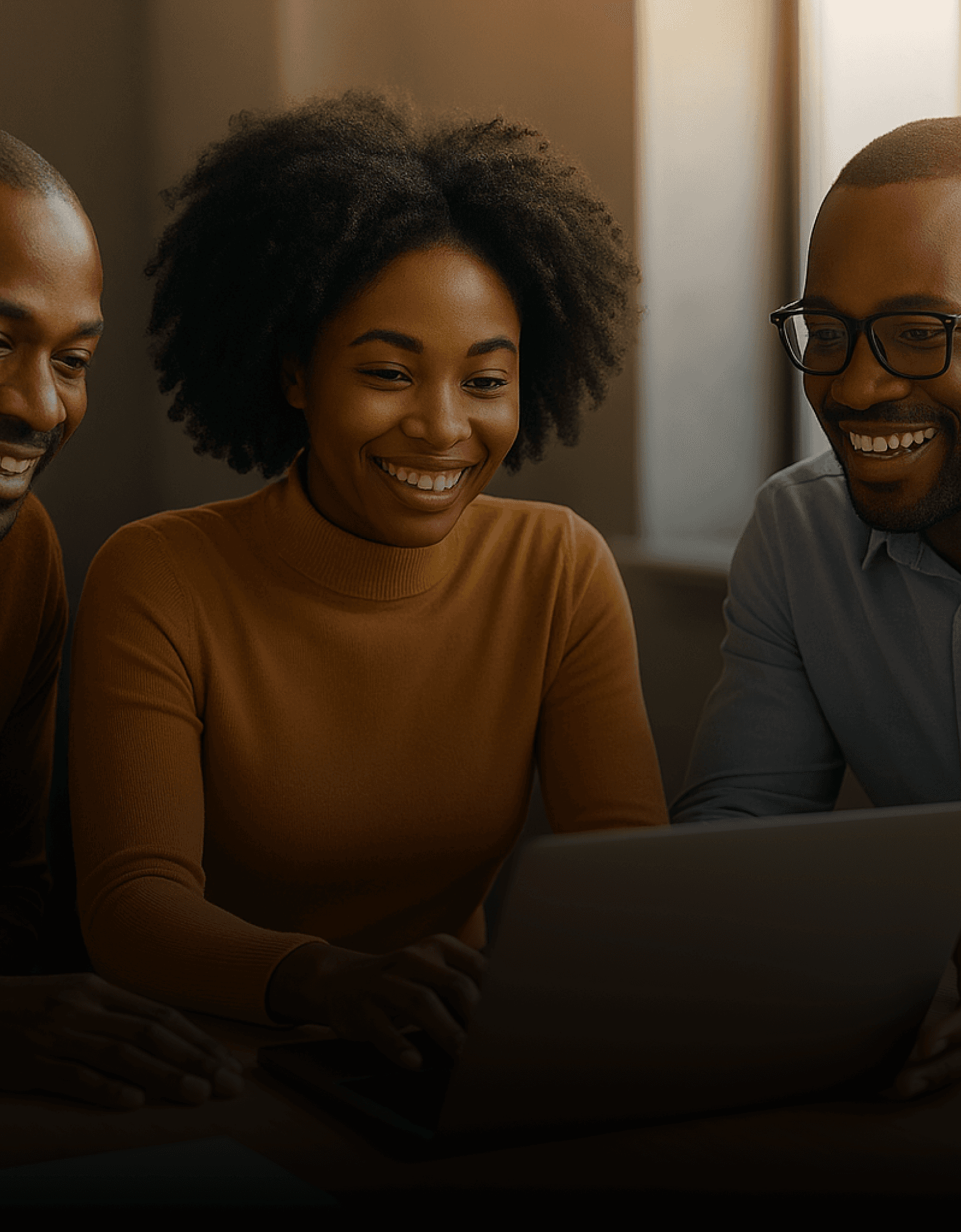 Group of people looking at laptop and laughing