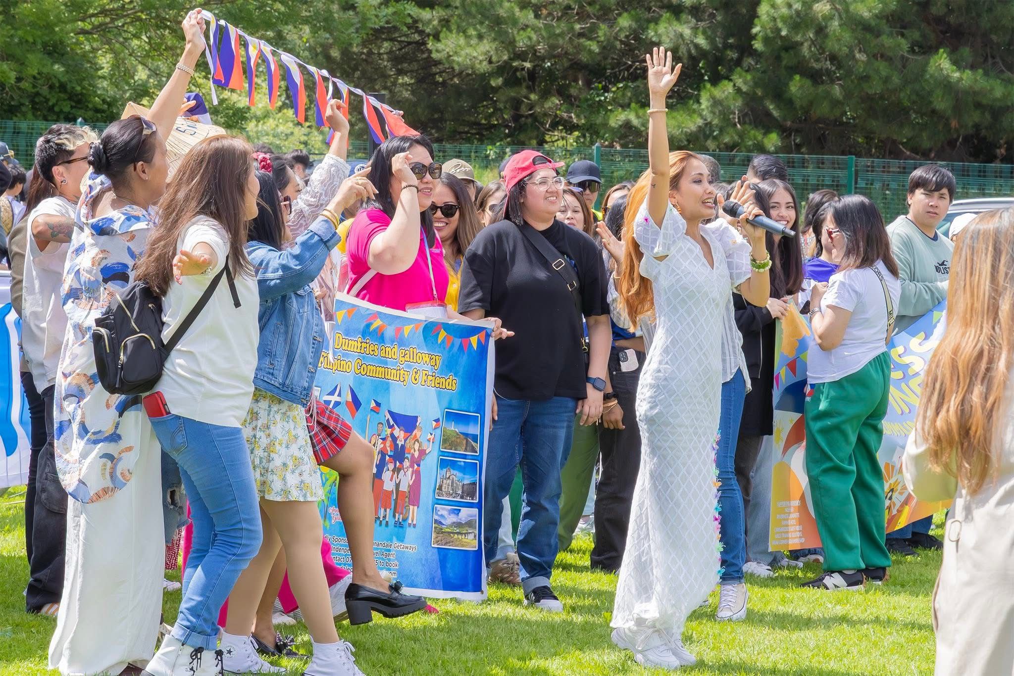 Three women holding hands at outdoor event