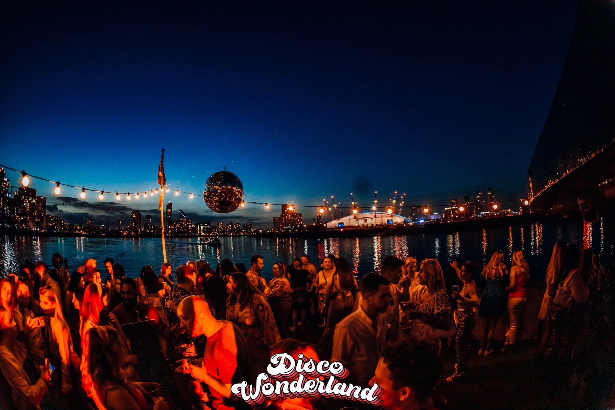 Disco ball glowing over the crowd late in an evening Disco Wonderland sailing