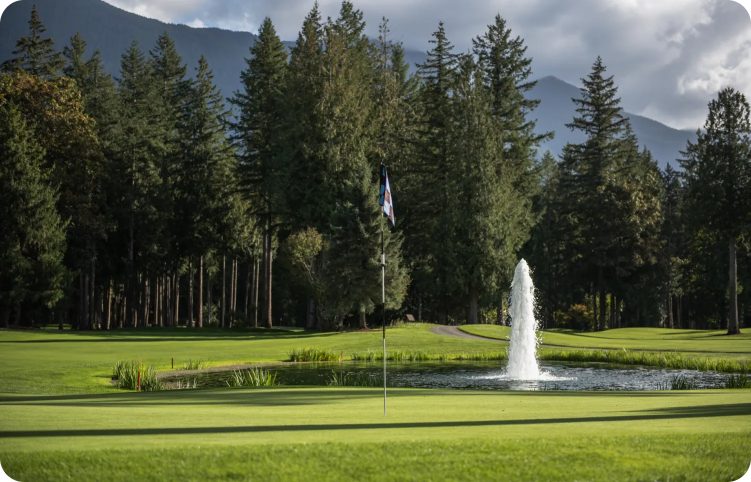 Golf course fountain with mountains in the distance