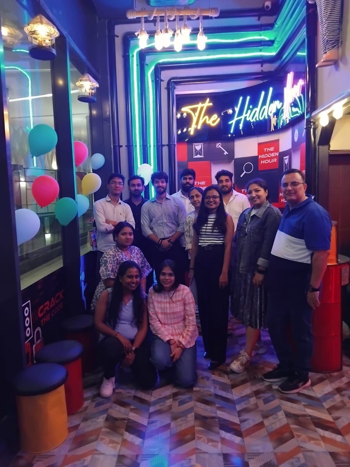 A team of 20 people posing for picture after the escape room game