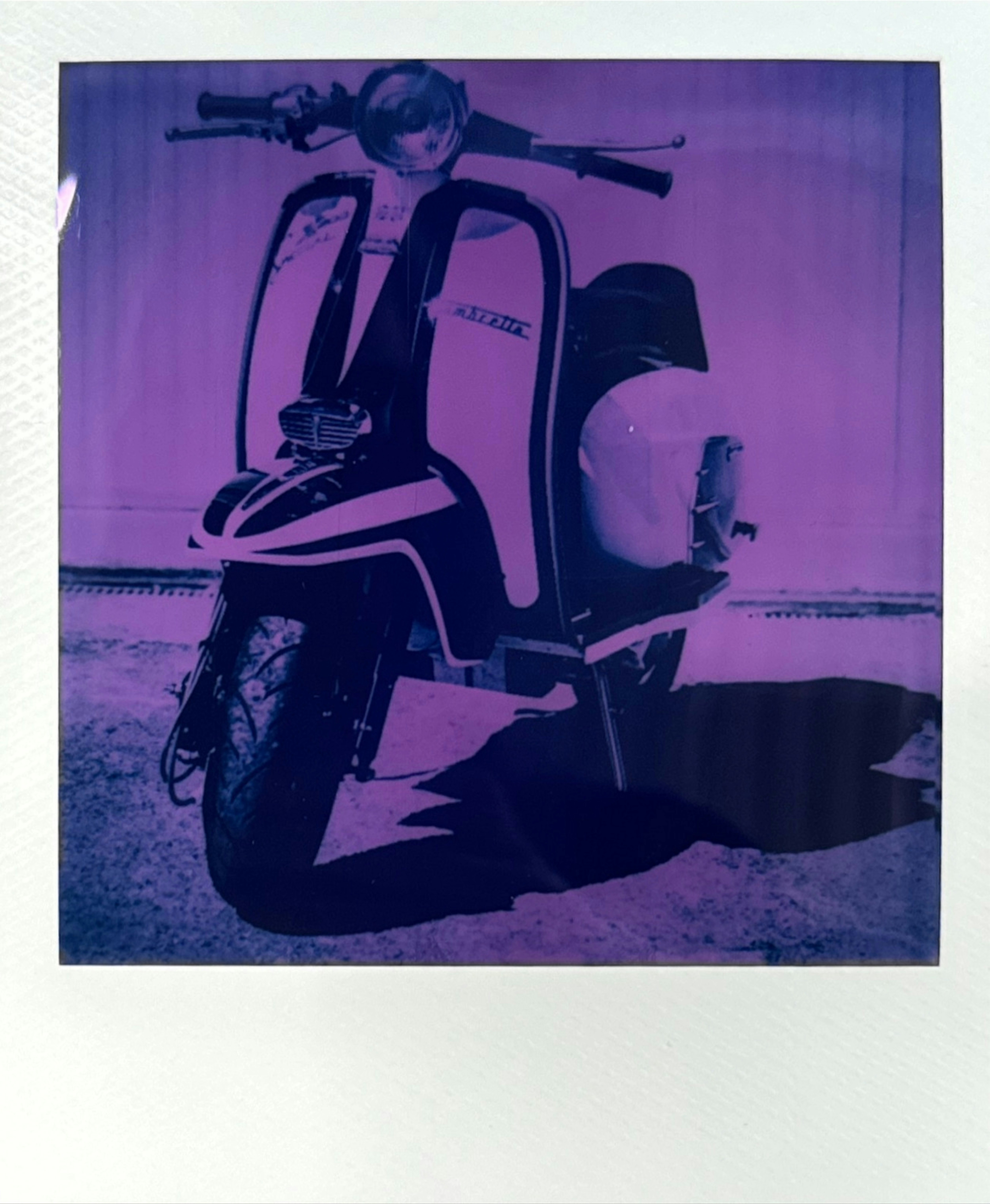 Purple-toned scooter captured on reclaimed polaroid film