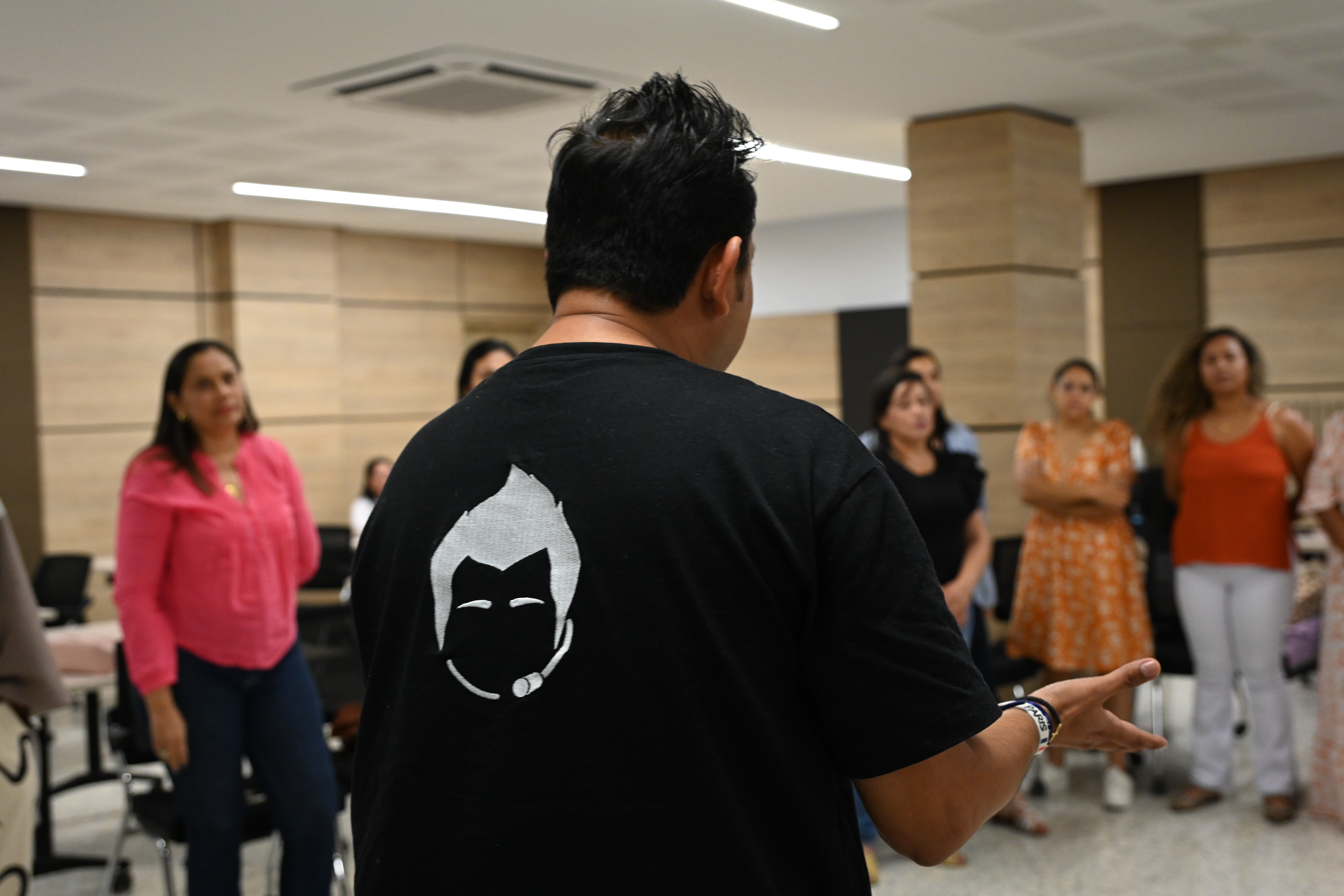 Jorge Baena de espaldas, guiando una dinámica con un grupo de mujeres en círculo durante un taller