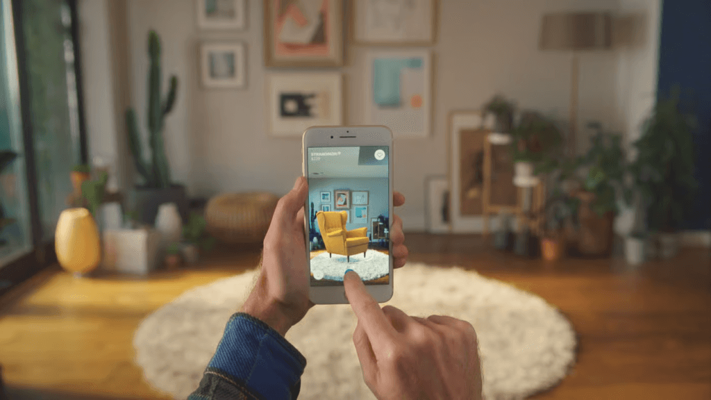 AR-App auf dem Smartphone platziert einen gelben Sessel im Wohnzimmer, Beispiel für Visual Commerce