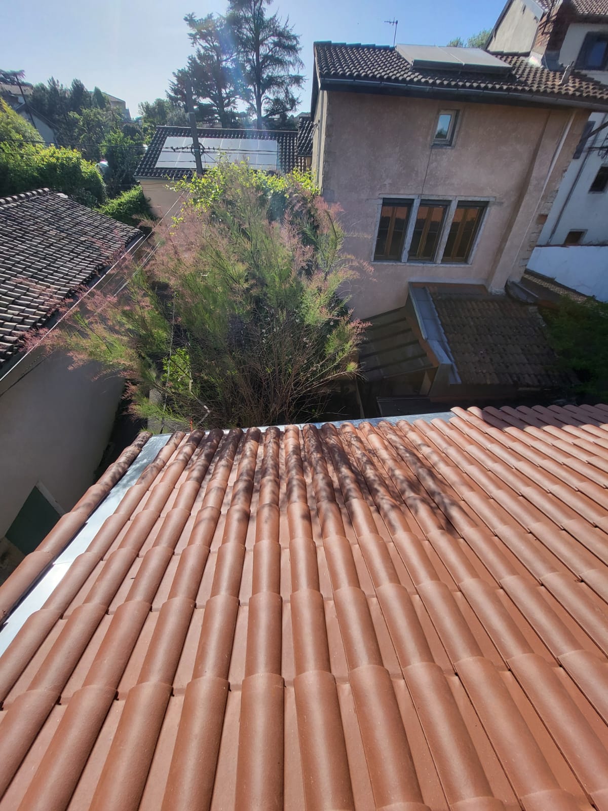 Couvreur Lyon posant des tuiles sur toit de maison