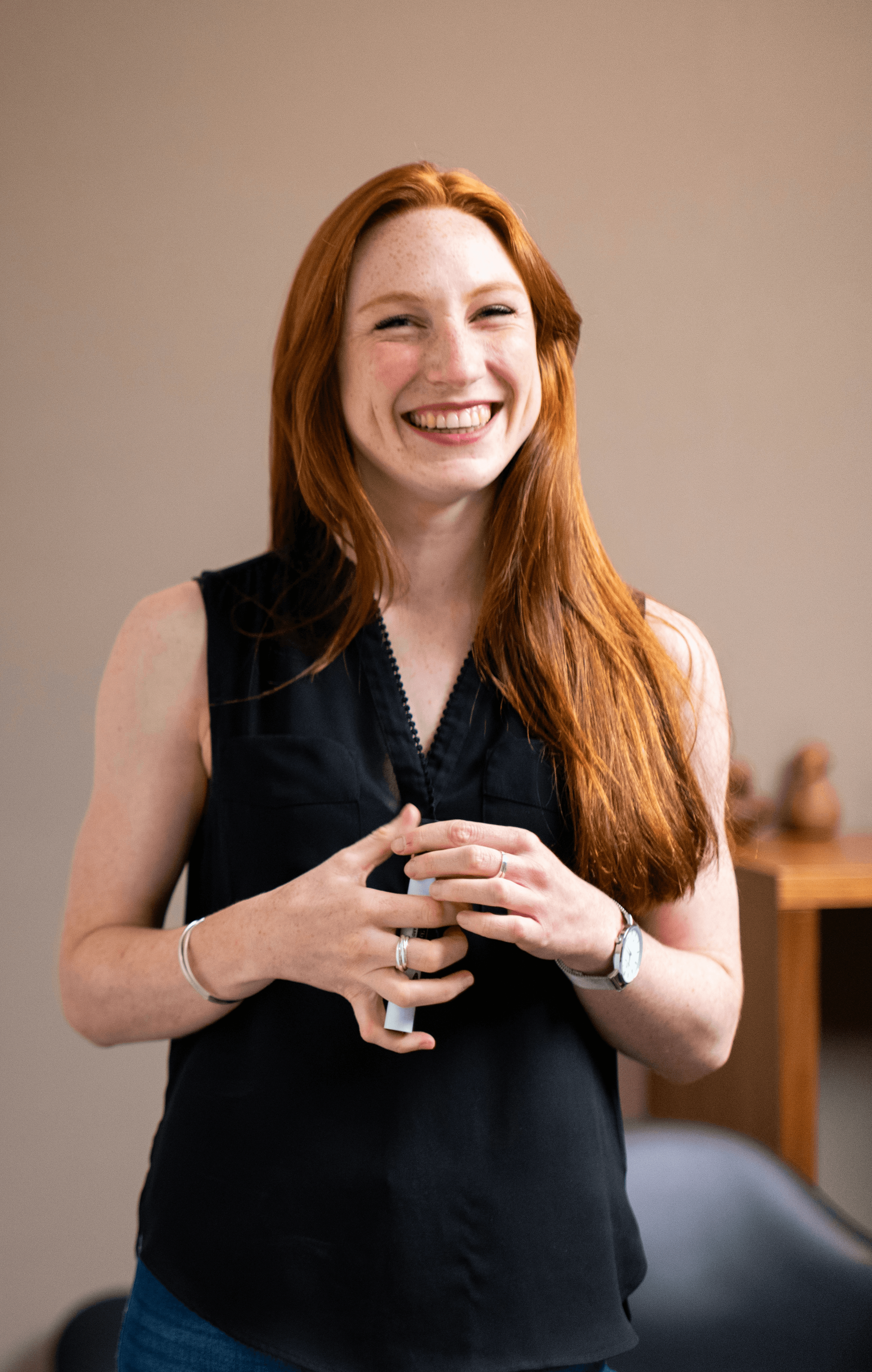 woman in blue tank top standing beside white wall