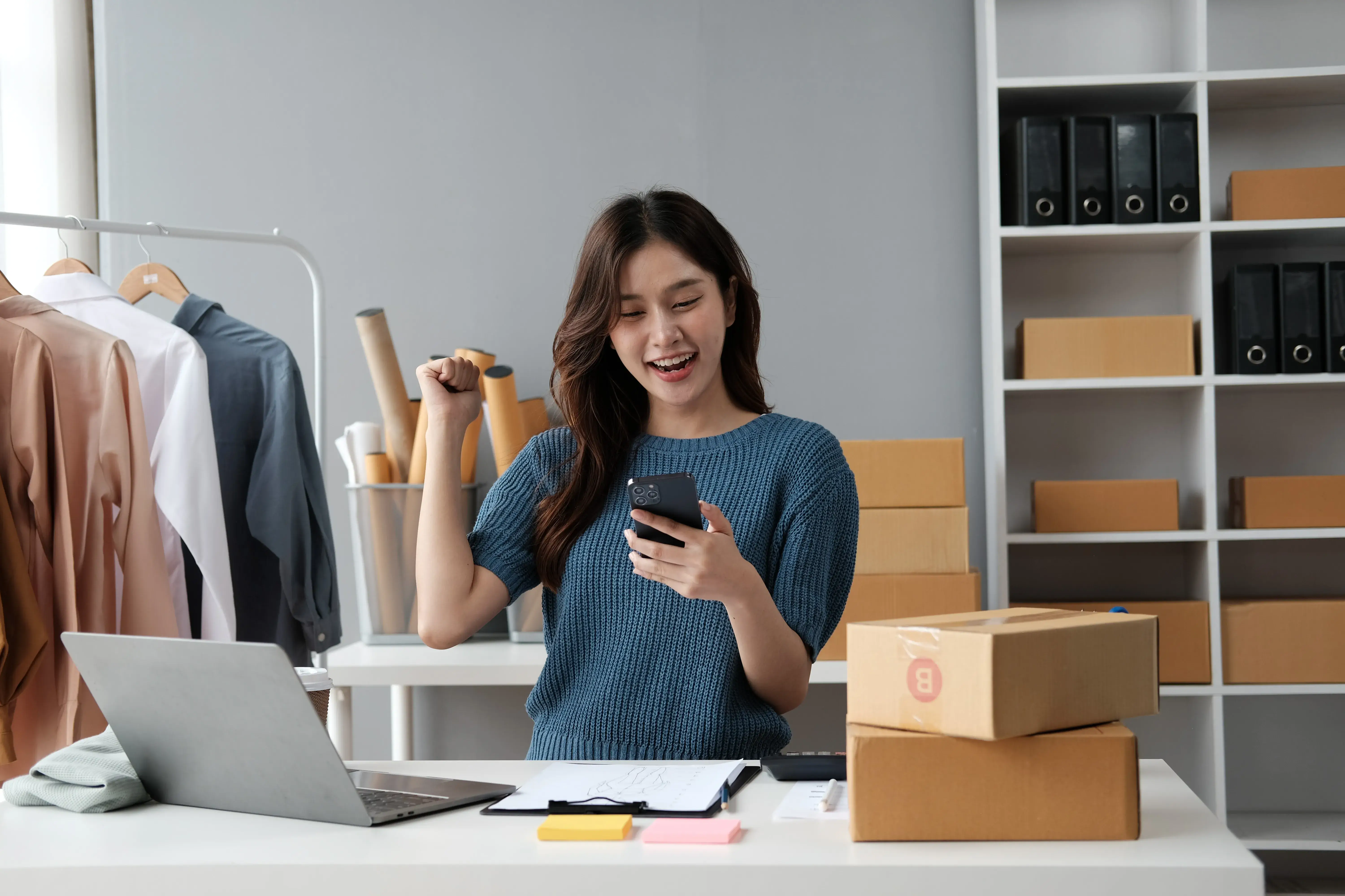 Retail business owner managing online orders alongside POS system.