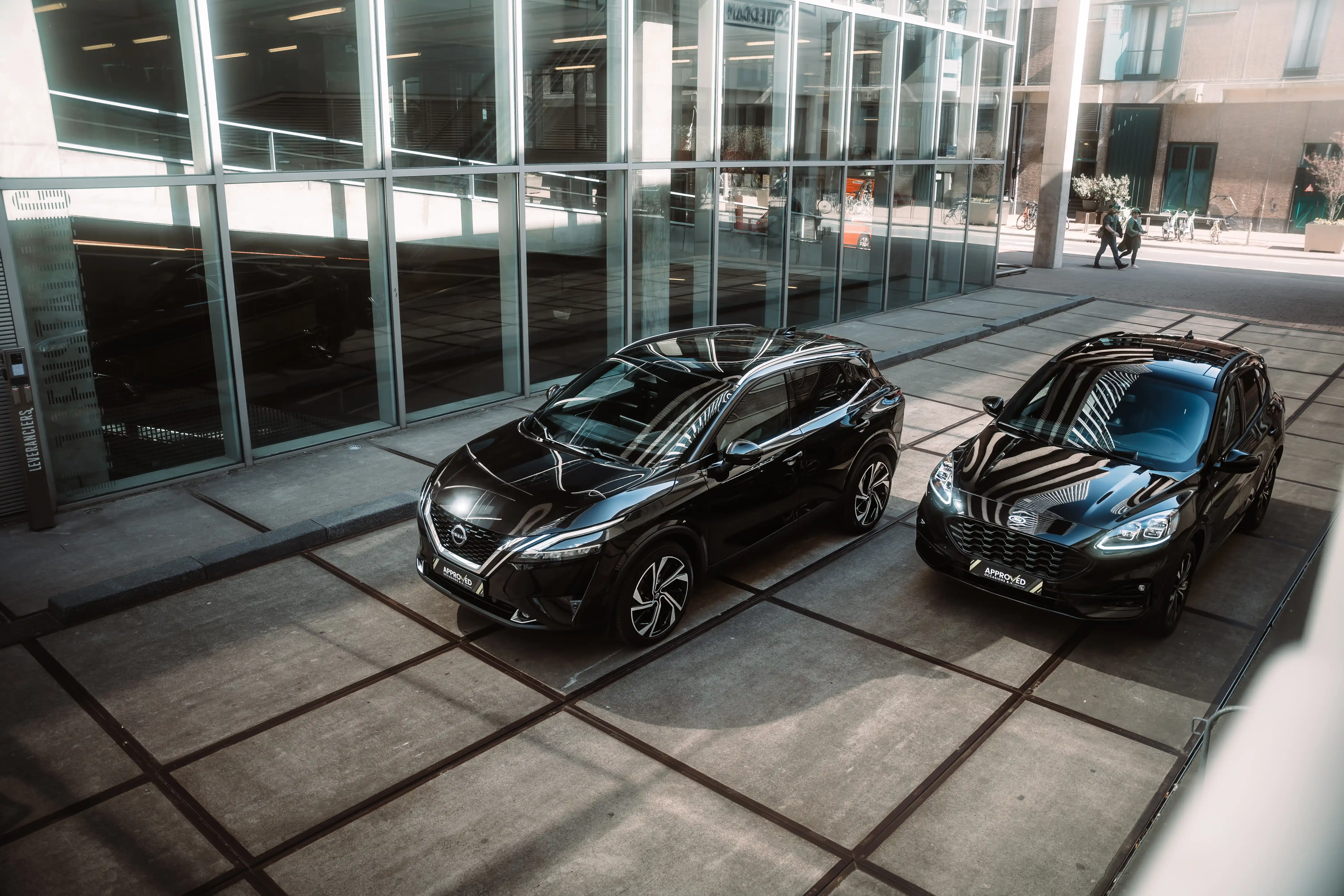 Topside view of two SUV's inside an alley of a urban city
