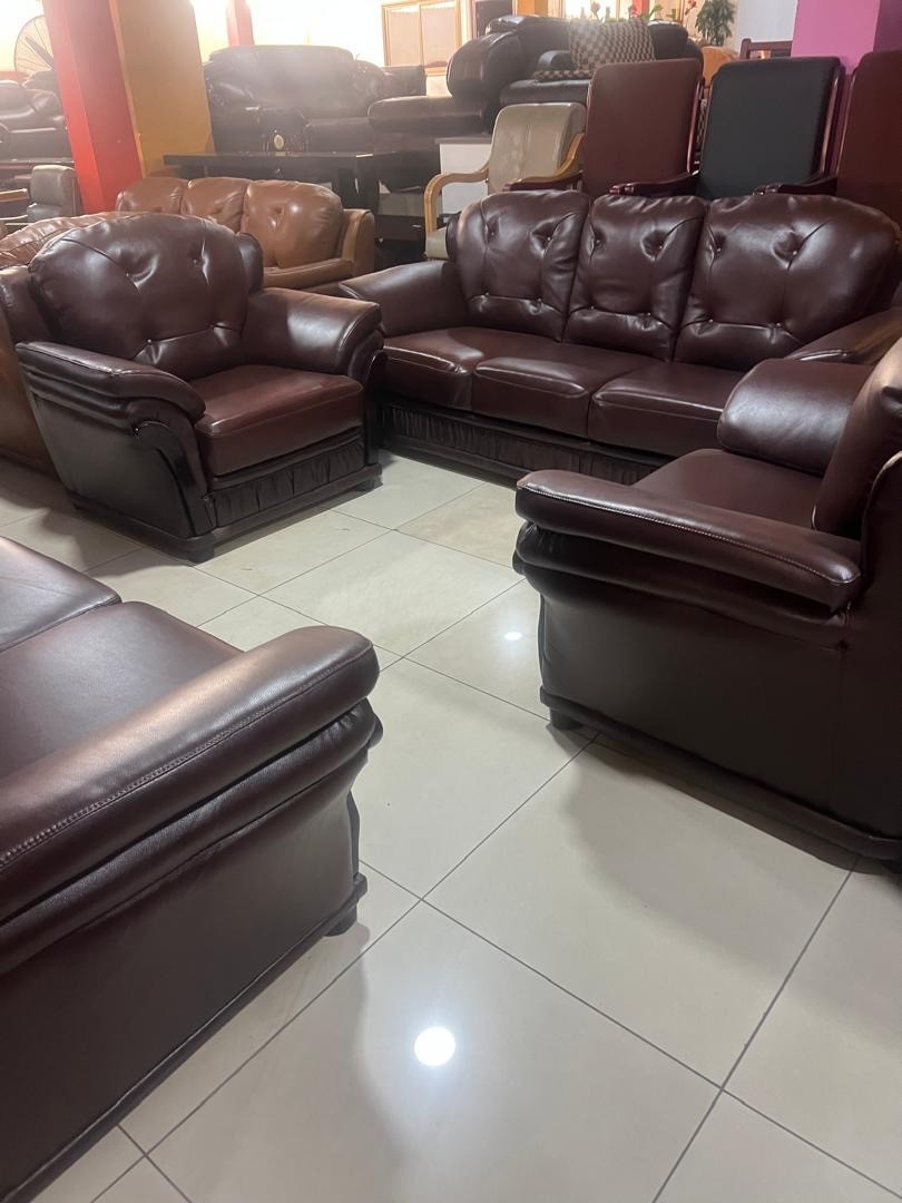 a gray couch with a wooden base on a gray background