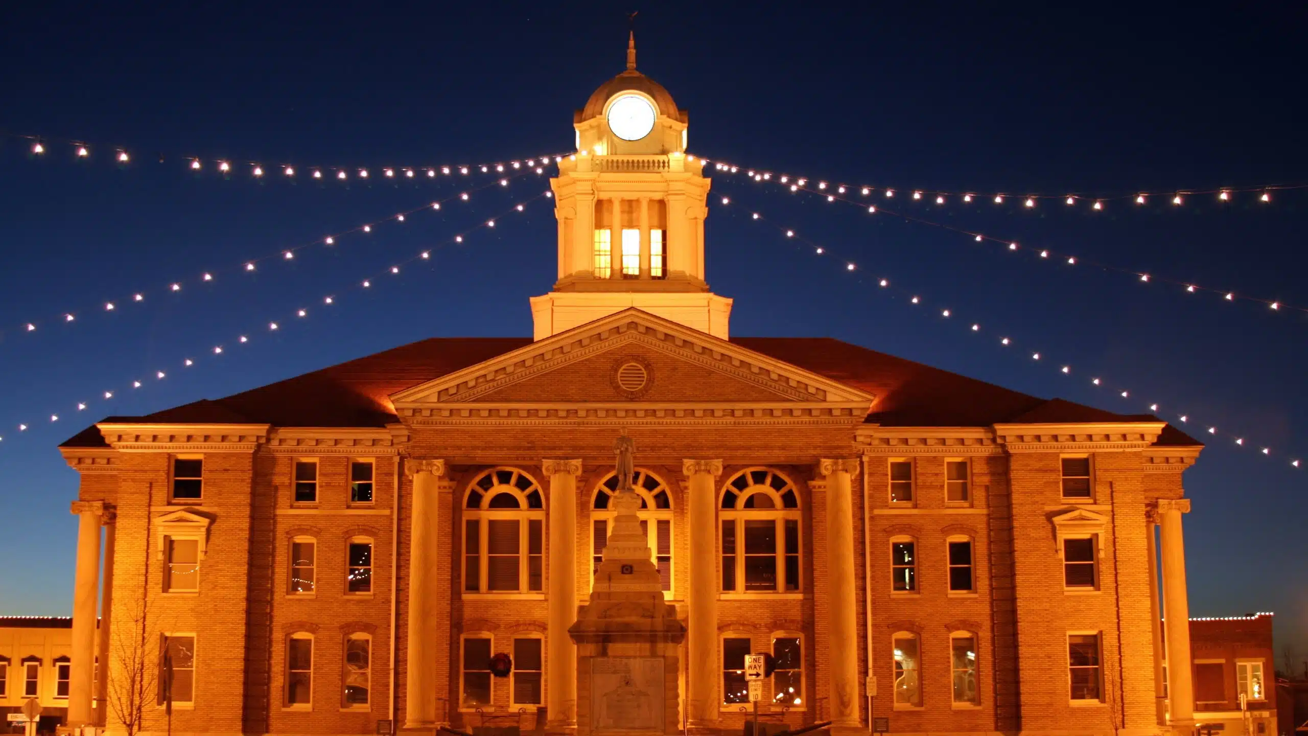 Aerial view of an intersecting dirt pathway forming an X-shape surrounded by lush greenery and arid, rocky terrain, illustrating a contrasting landscape.