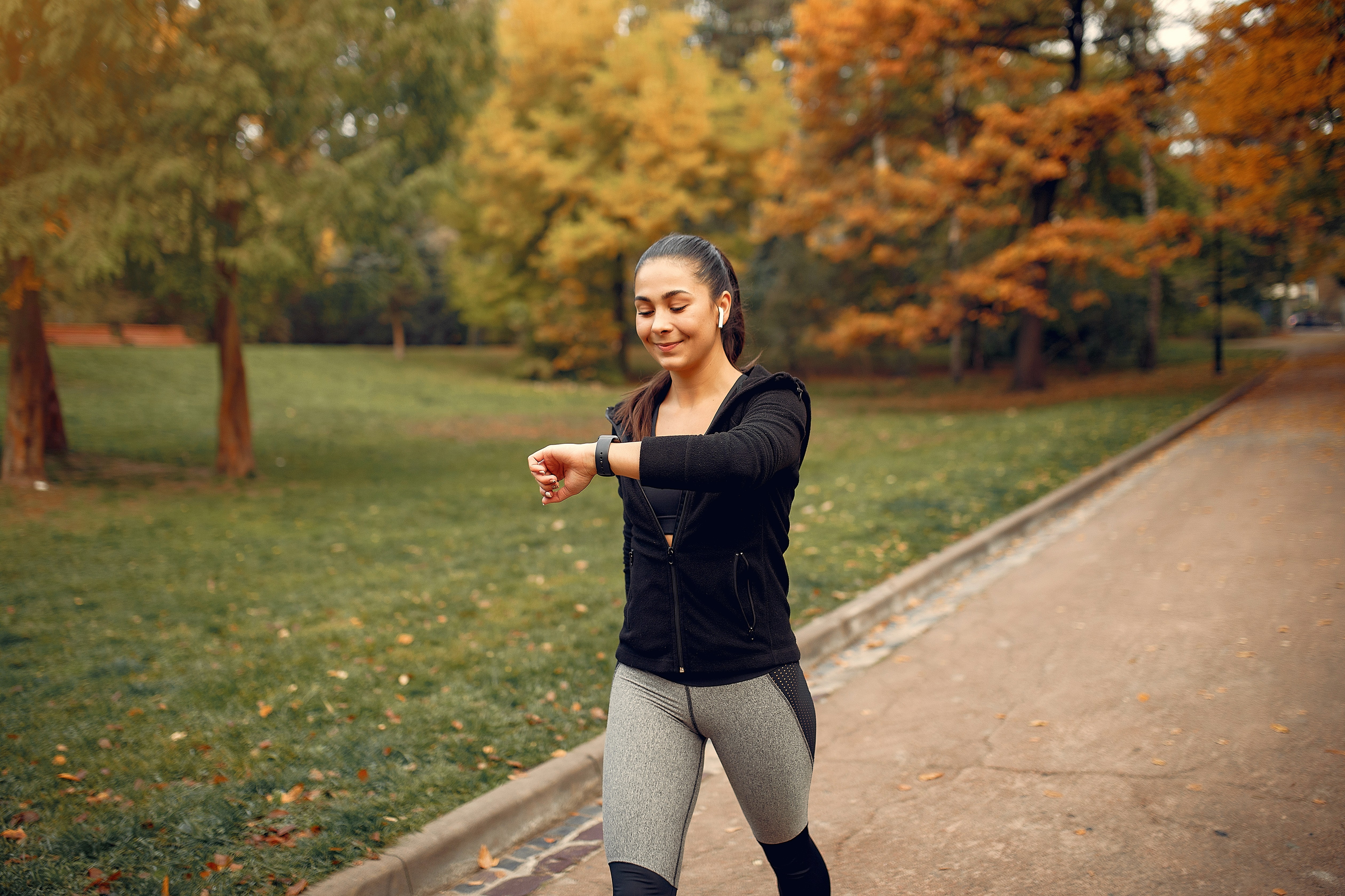 A girl walking in a garden and checking her activity in watch