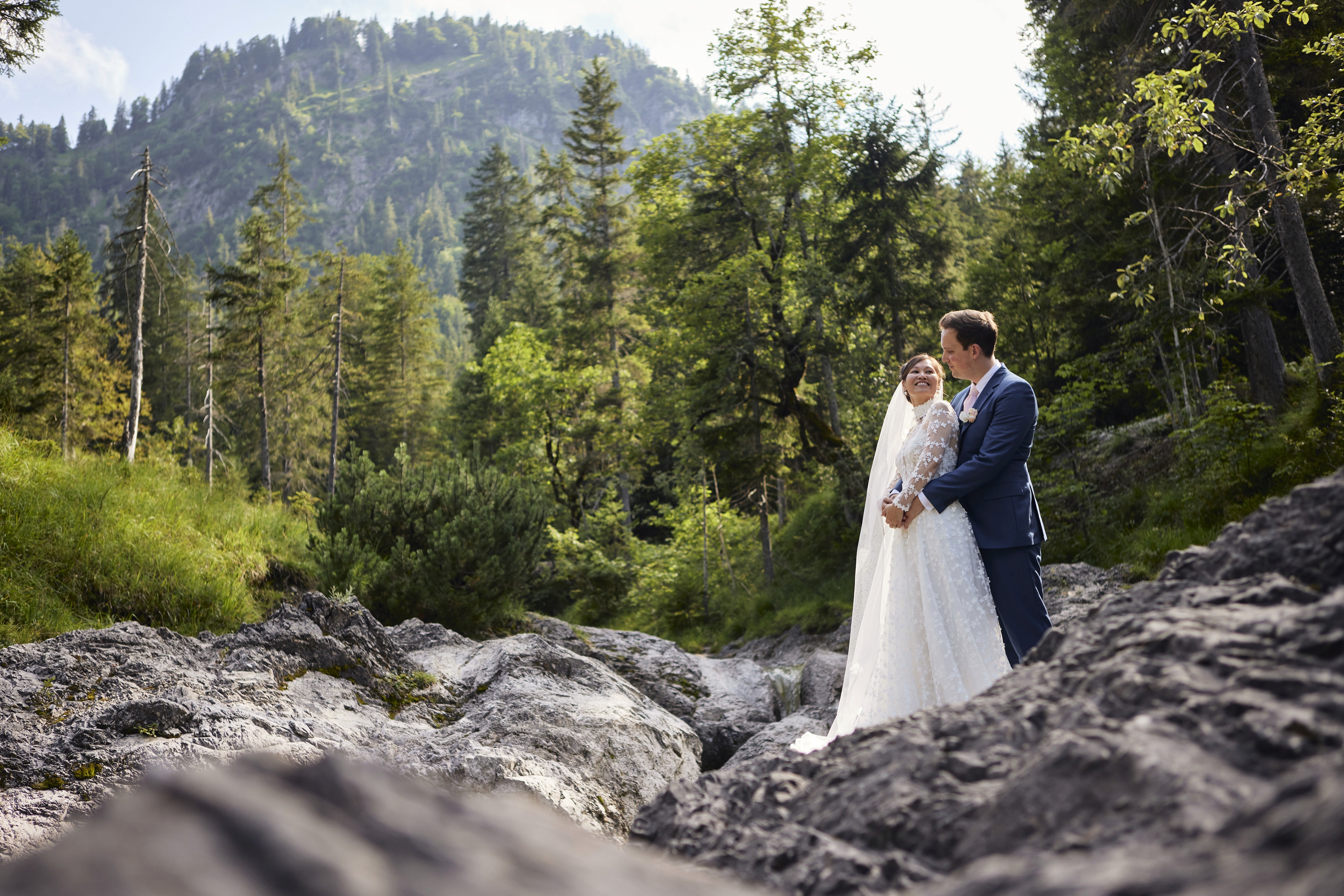 Couple embracing among rocks and forest, alpine elopement photography Bavaria