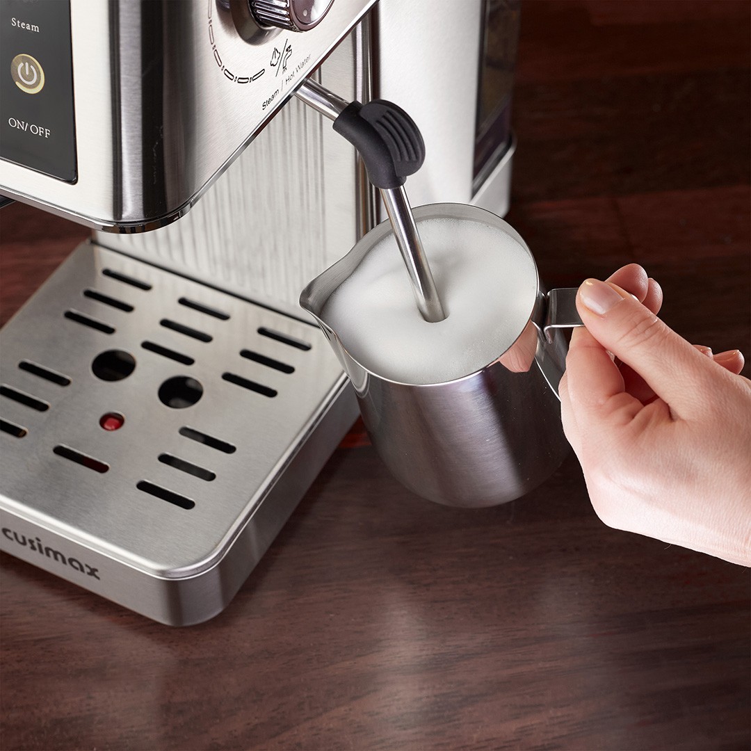 A close-up image of a stainless steel espresso machine's steam wand frothing milk in a metal pitcher, highlighting the process of making a creamy latte.