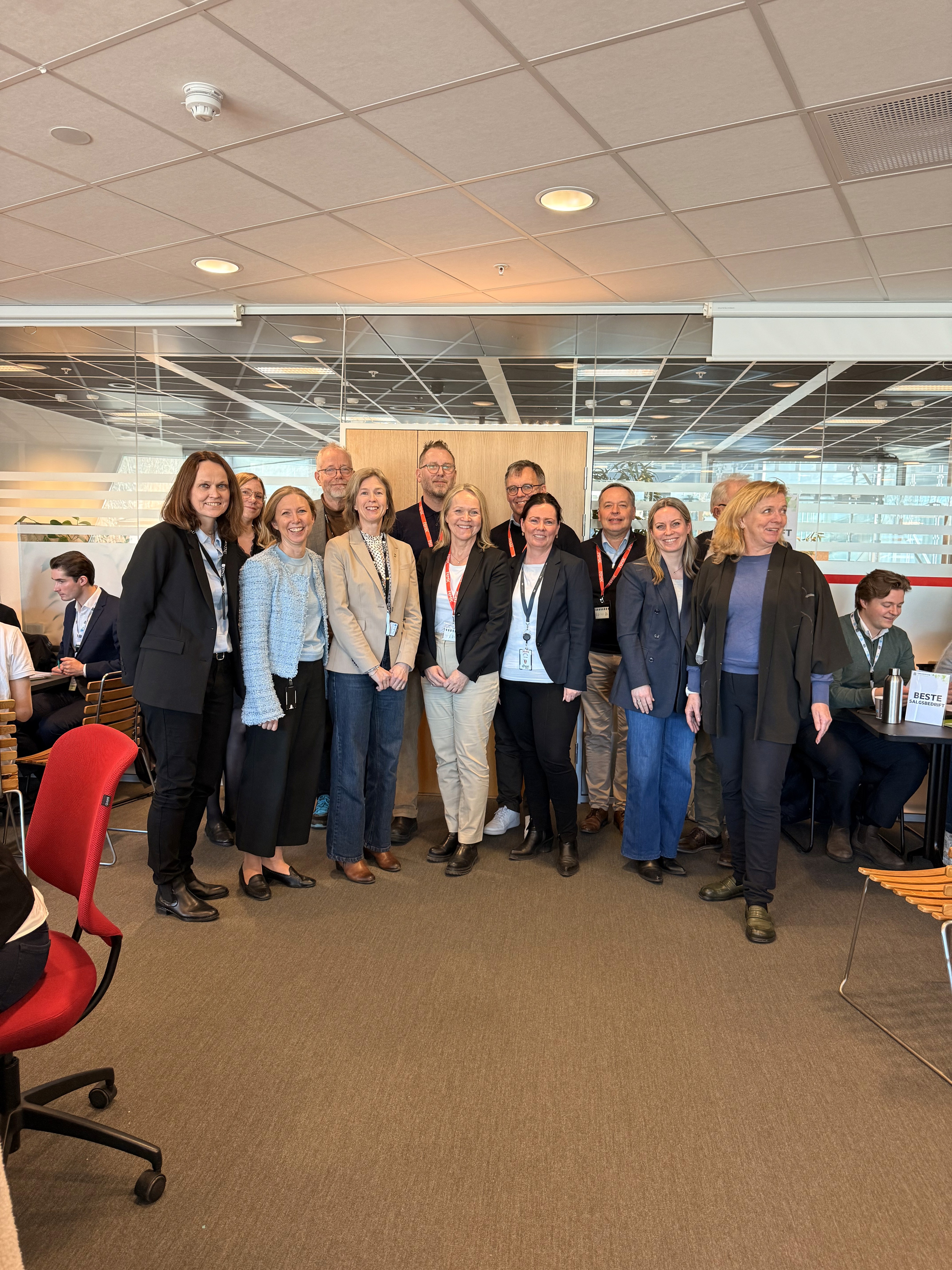 A person wearing a virtual reality headset stands in front of multiple screens, engaged in a digital experience.