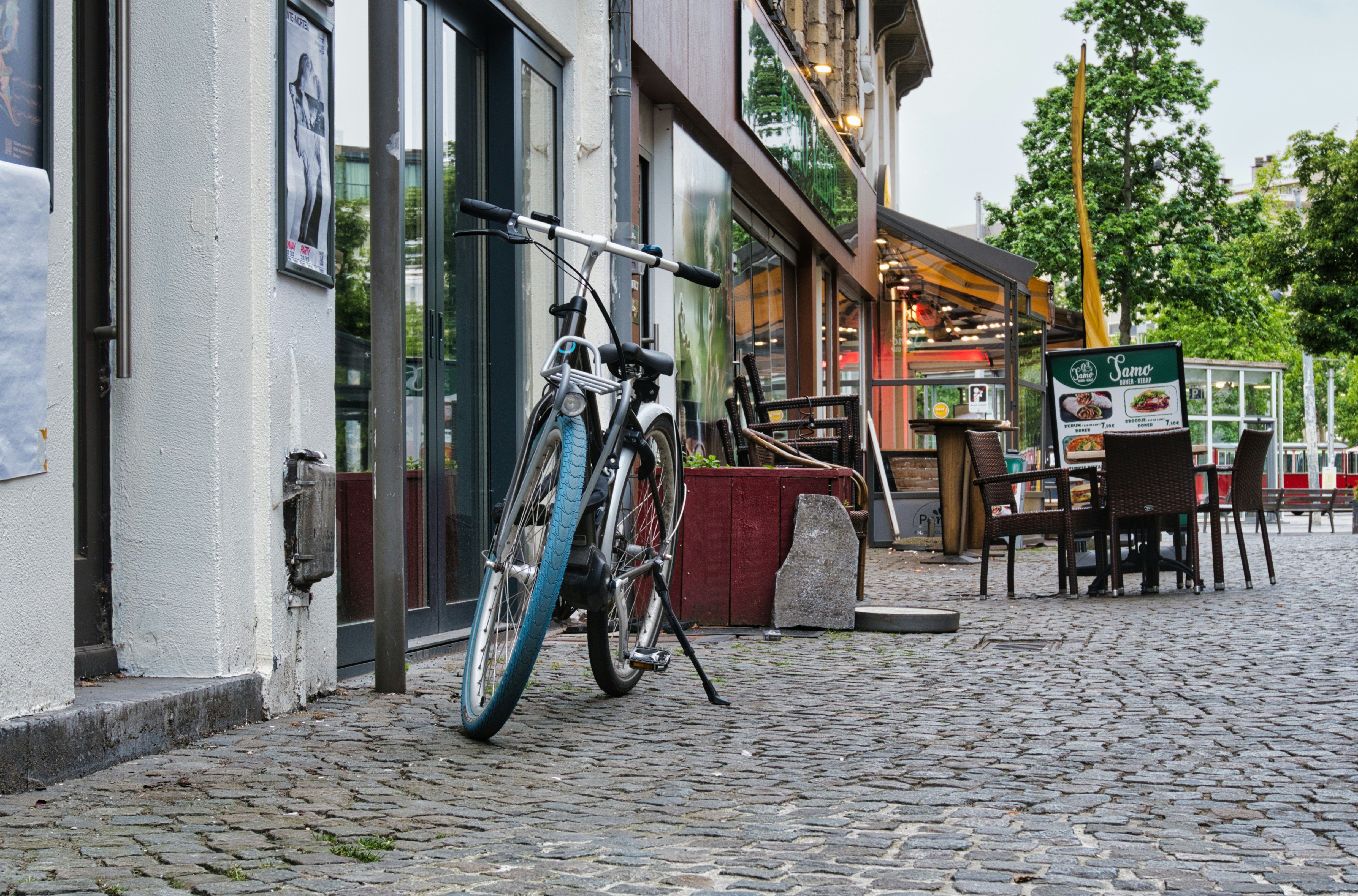 A bicycle is parked outside a cafe.