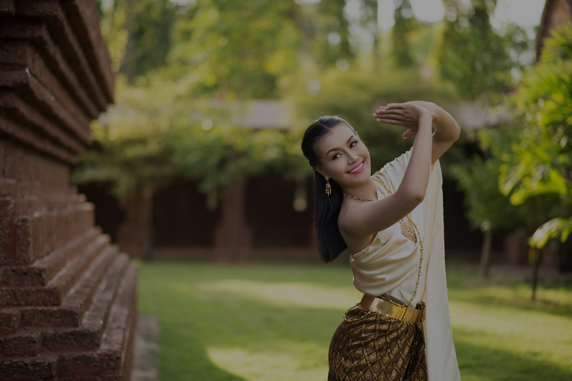 Beuatiful Thai Female in her 20s in traditional Thai clothing in an outdoor setting