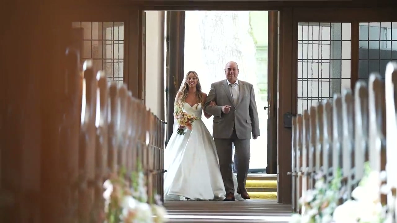 Videostill: Braut zieht mit ihrem Vater in die Kirche ein