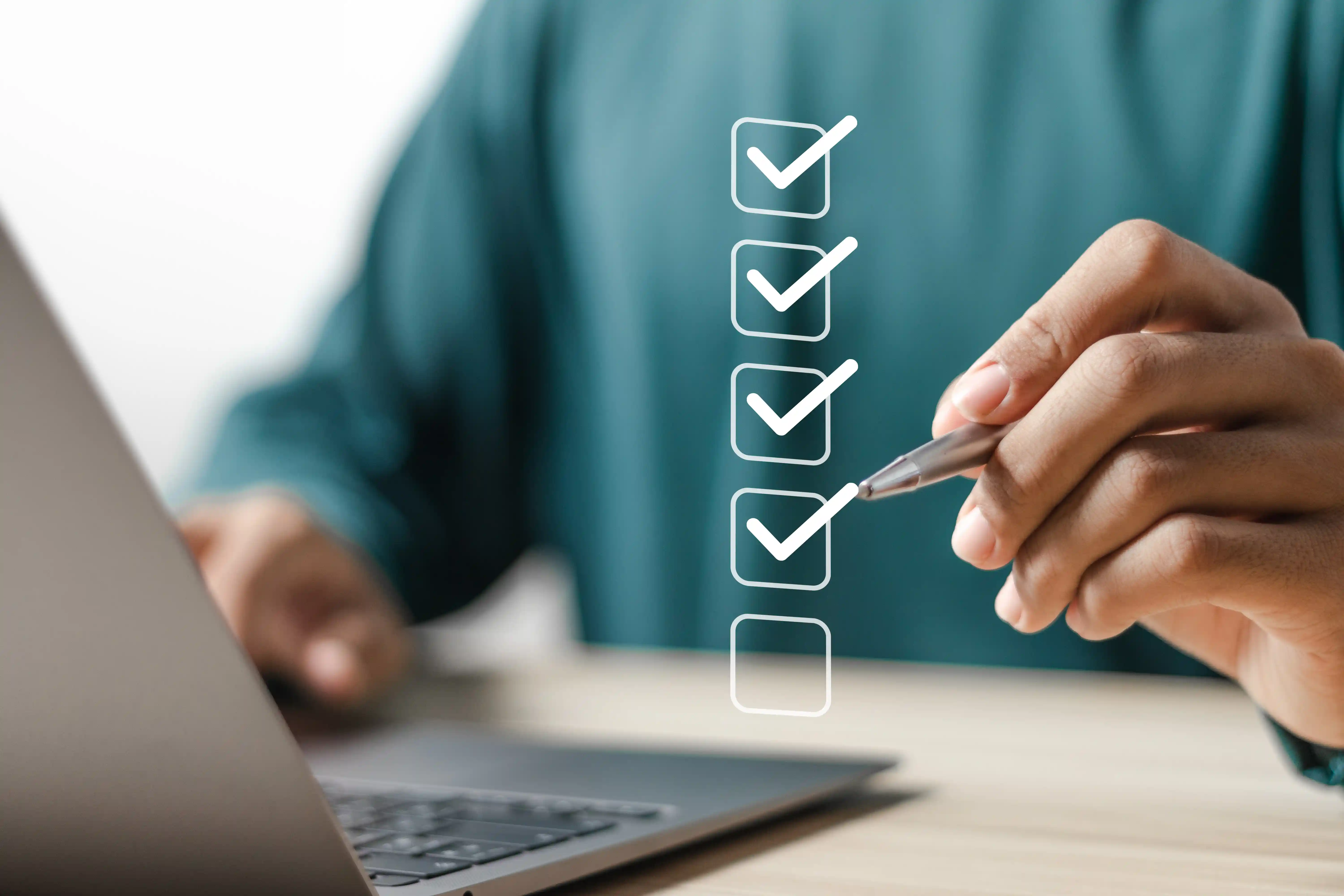 Man researching on laptop and completing a checklist