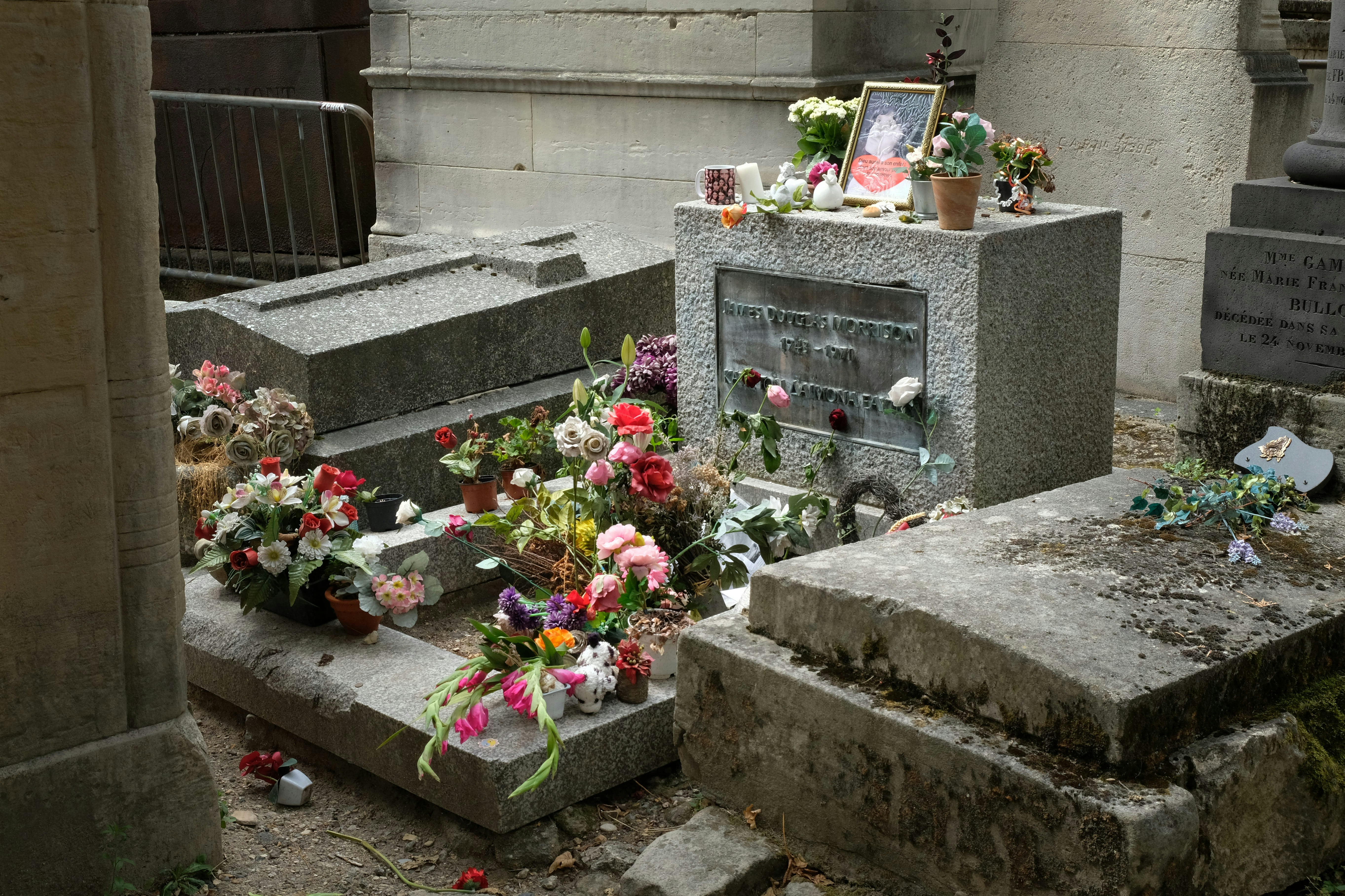 A grave adorned with flowers and a framed picture.
