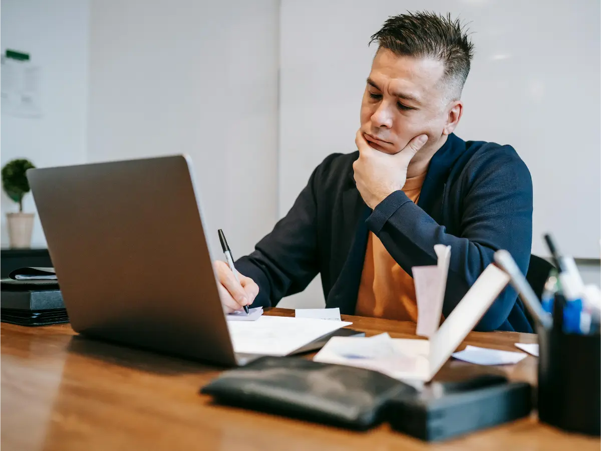 Yrittäjä työskentelee kannettavan tietokoneen äärellä ja pohtii asiakkuudenhallintaa. Kuva havainnollistaa CRM-järjestelmän ja Excelin vertailua pk-yrityksen näkökulmasta.