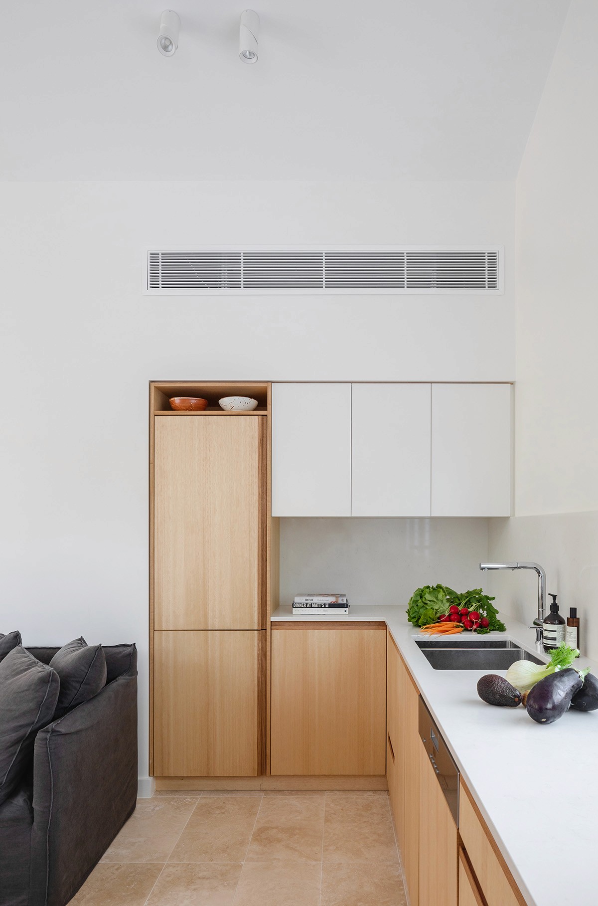 Minimal kitchen interior with pale timber cabinetry, integrated appliances, and a clean white palette that enhances the compact footprint of the Treehouse.