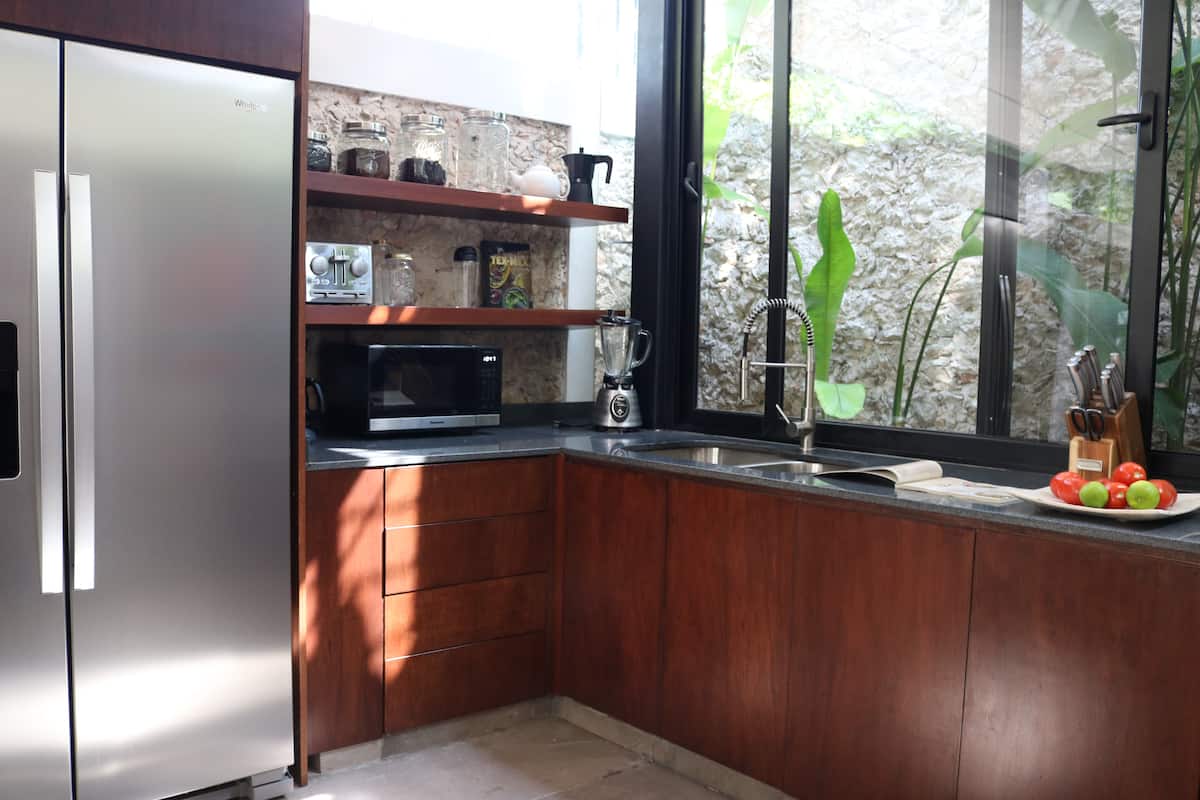 Casa Piedra kitchen with warm wood cabinetry and garden view