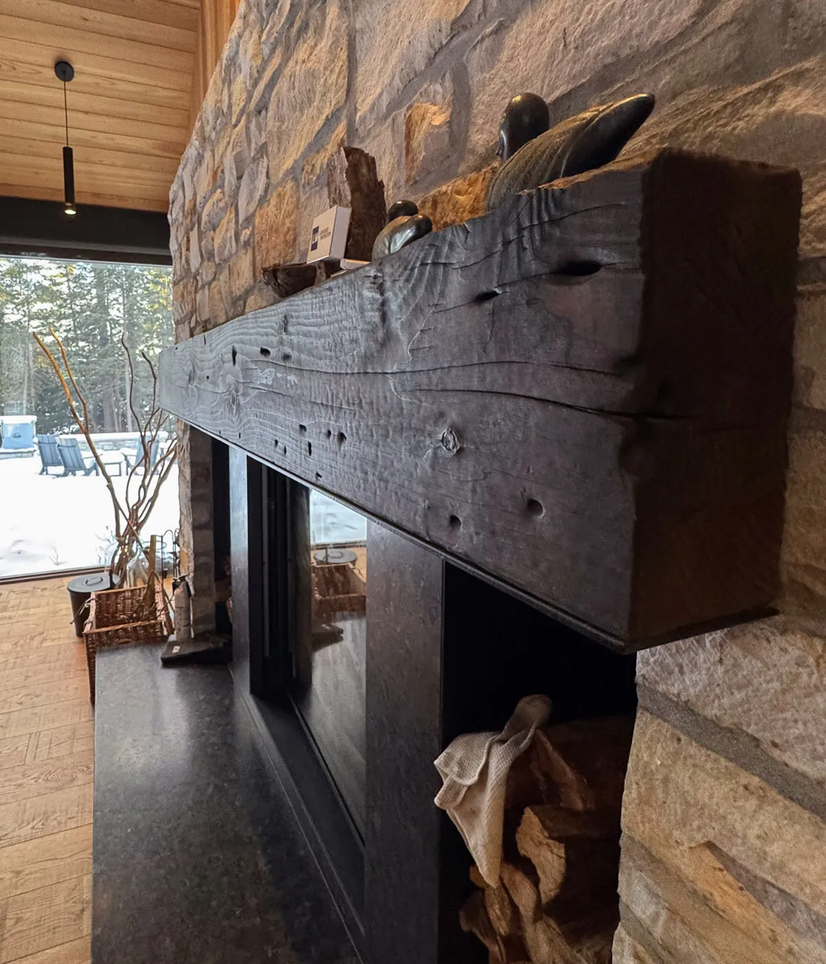 custom burn brushed fireplace mantlepiece in front of granit masonry.