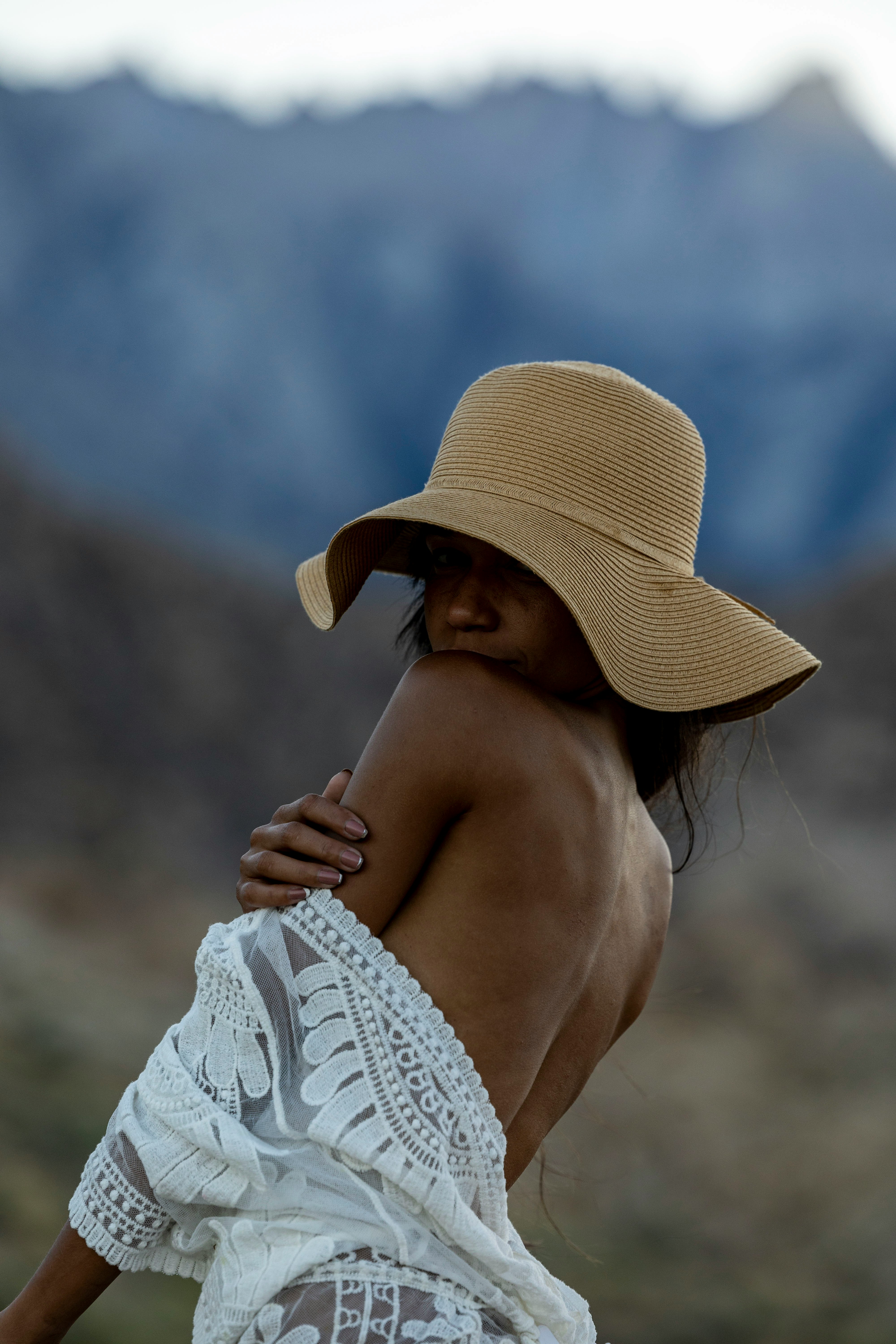 a woman wearing a hat and a white dress