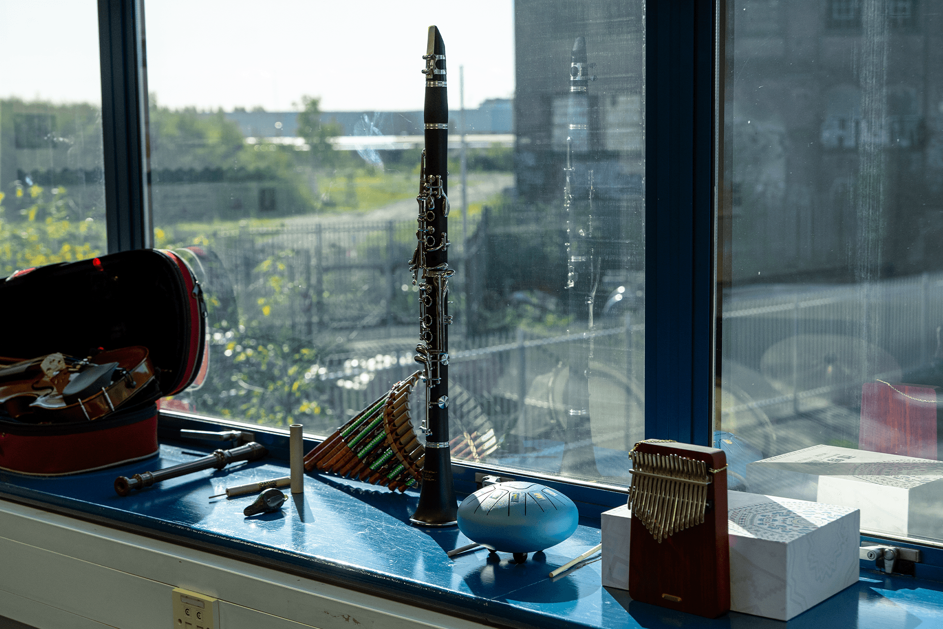 Photo of a diverse collection of musical instruments, including a clarinet, a flaute, and a violin, neatly arranged for use in a music room