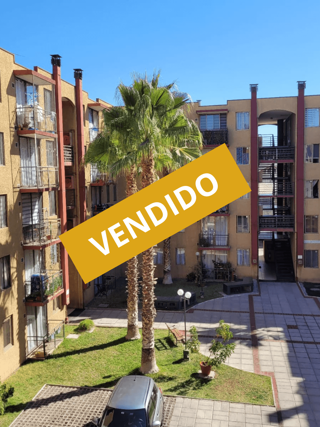 Medieval stone castle wall and tower with orange roofs against a pale sky.