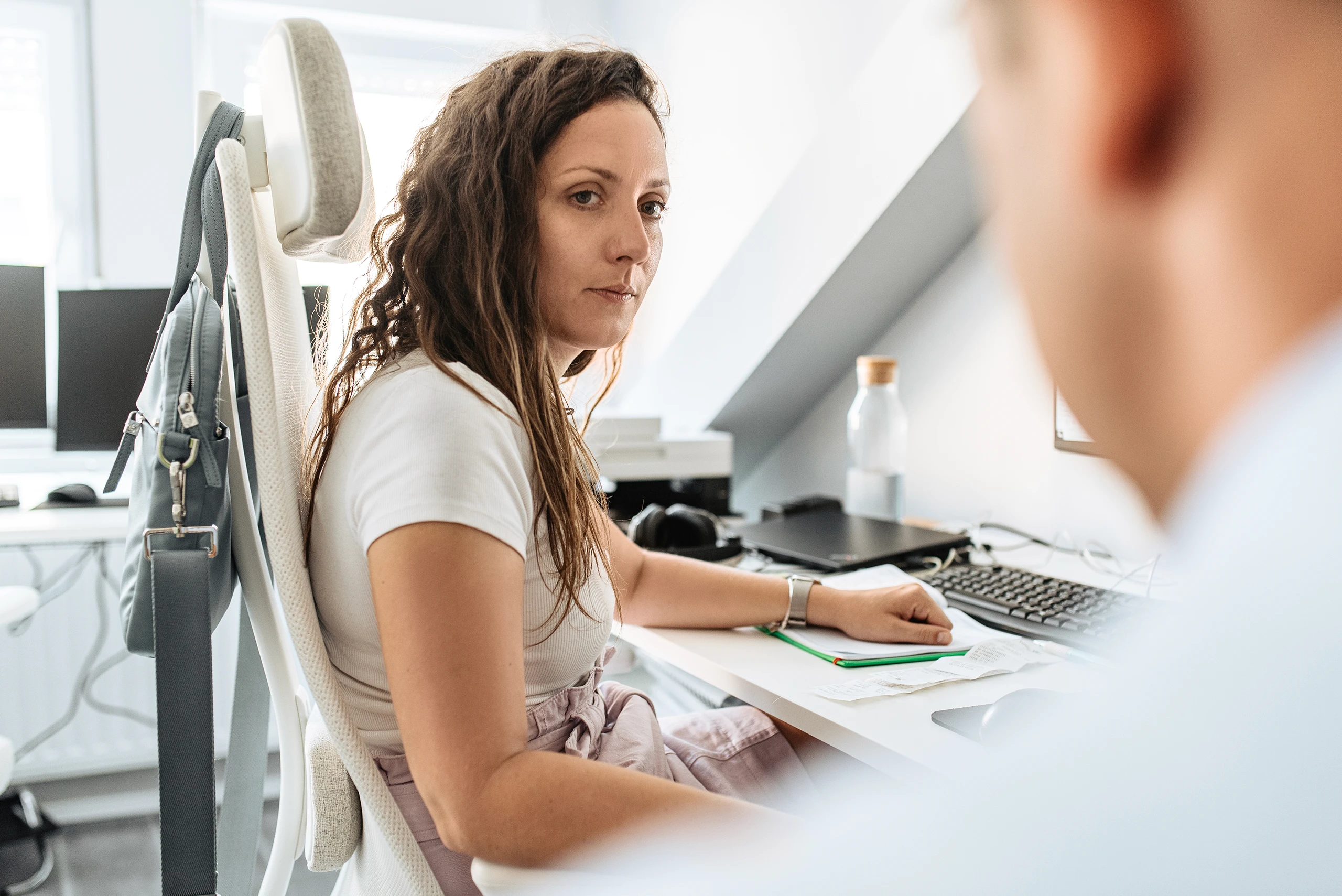 Employee working at a desk in a bright, modern office environment.