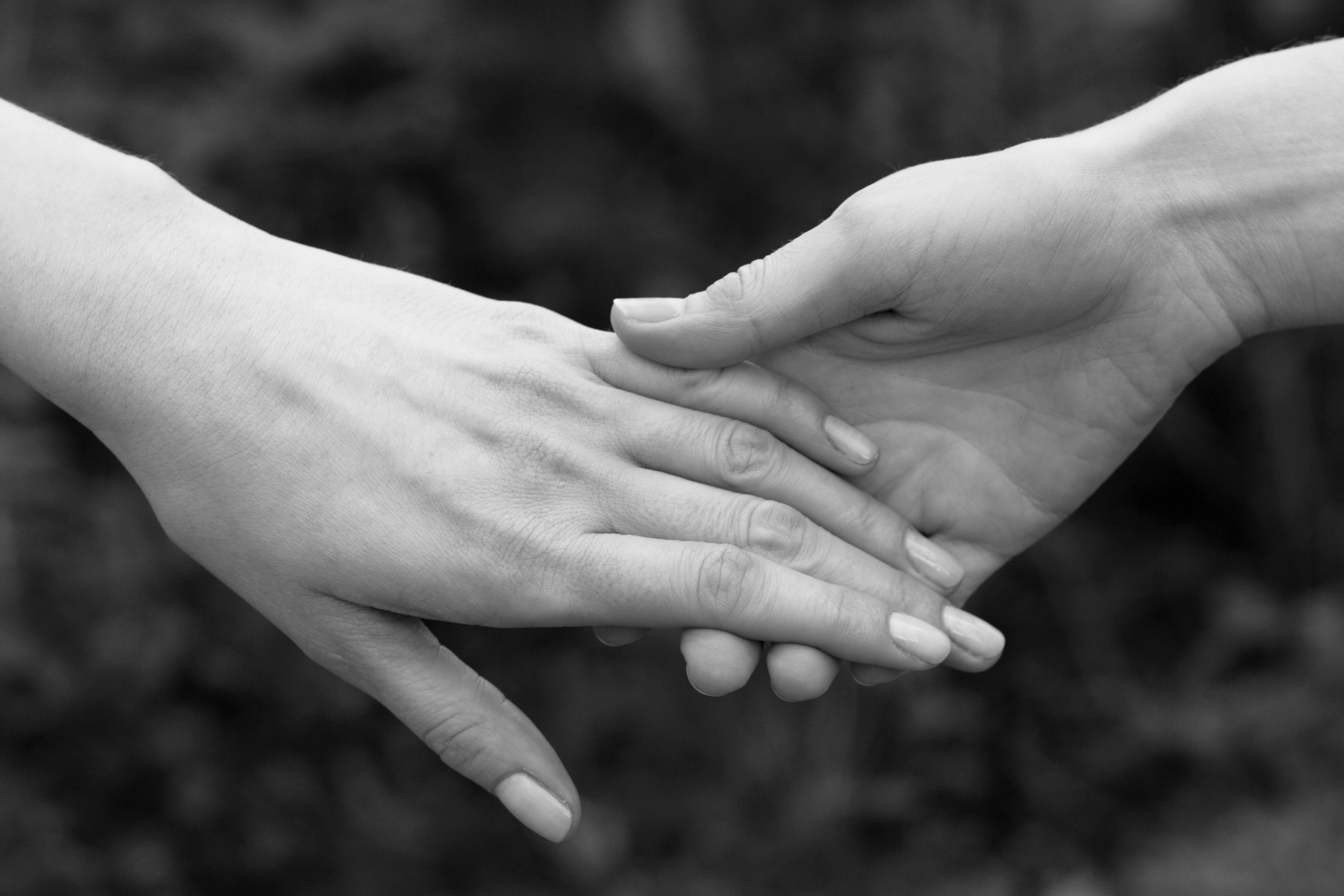 a couple of people holding hands over each other
