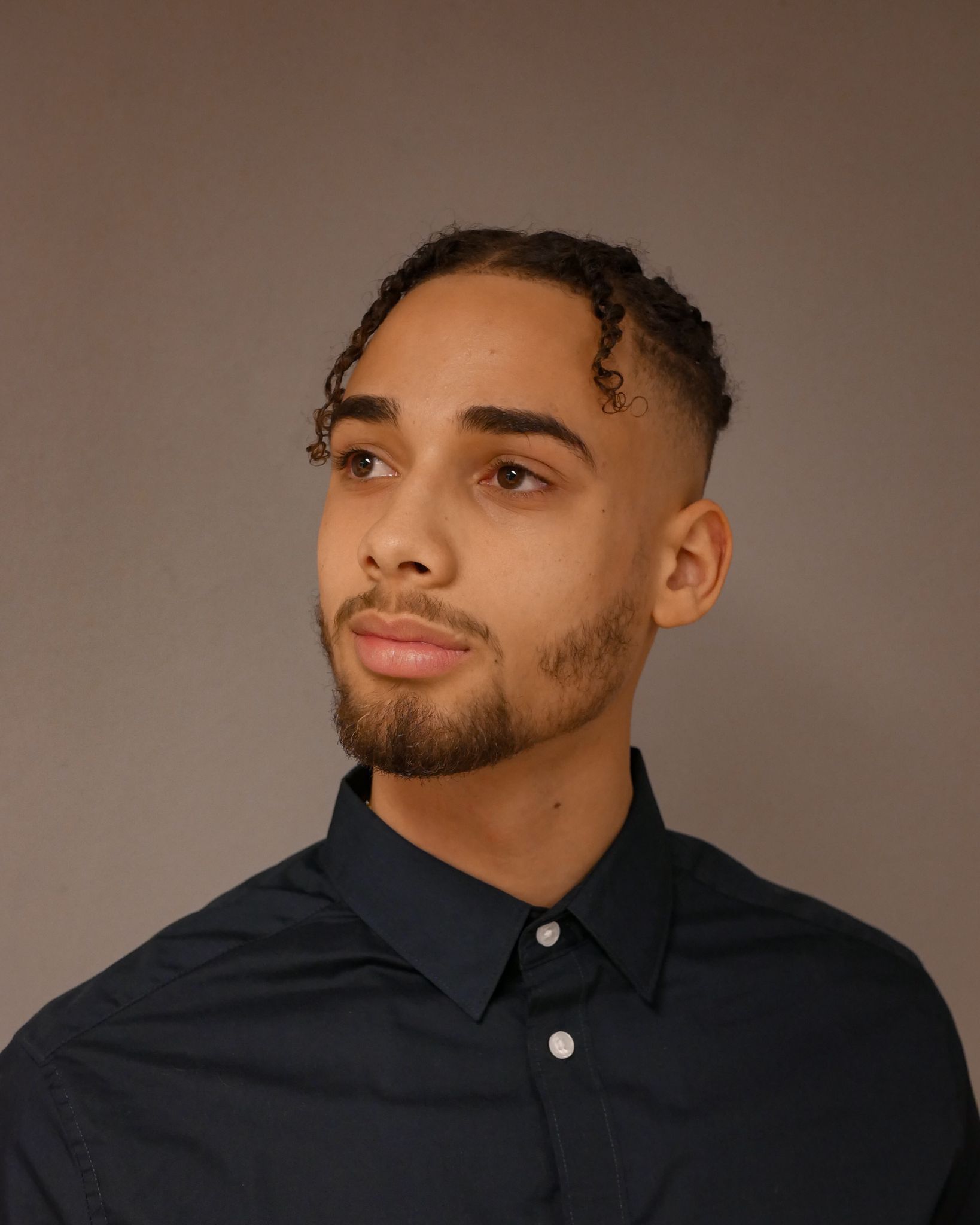 Profile portrait of a man in a grey shirt