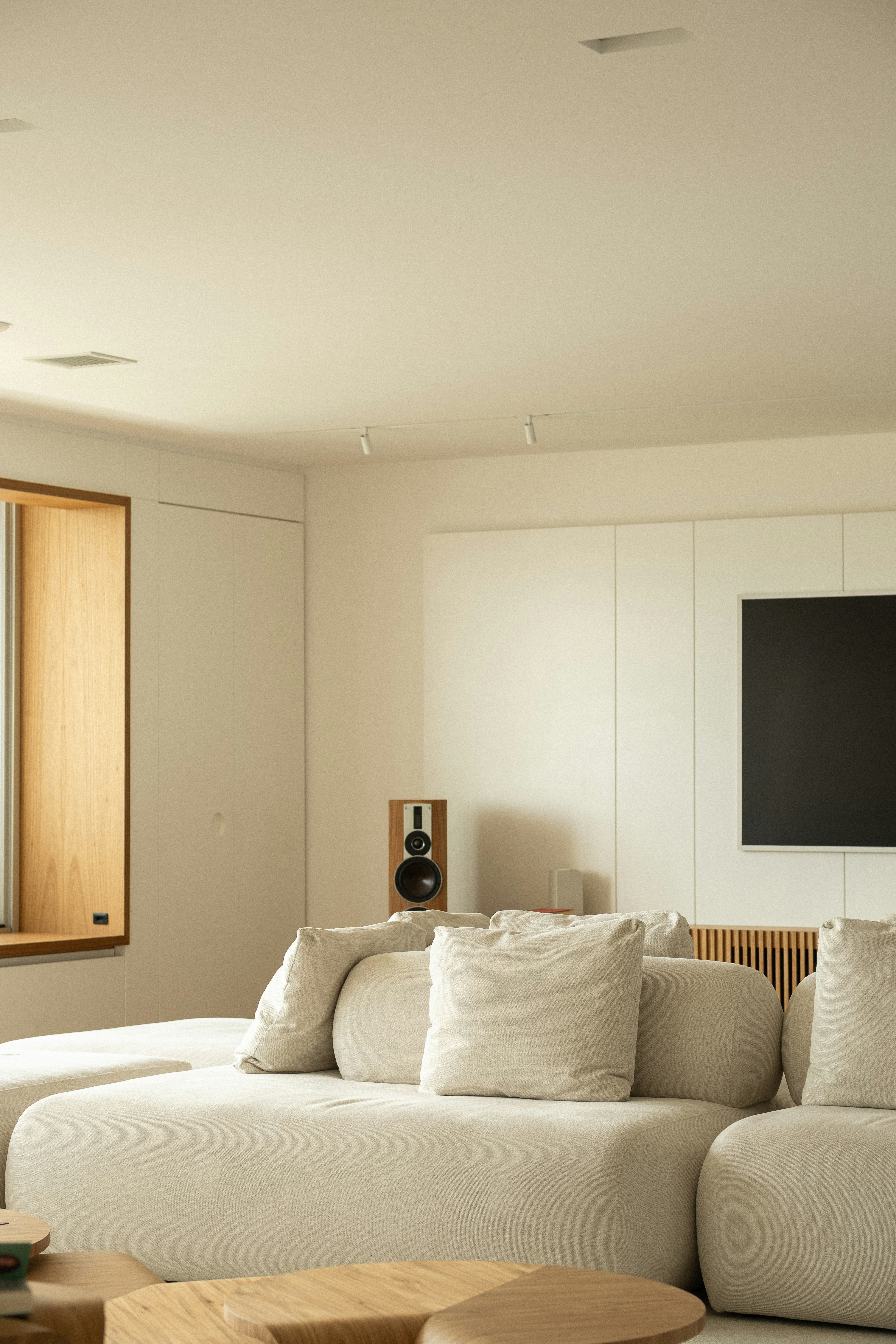 Modern living room with sectional sofa and speaker.