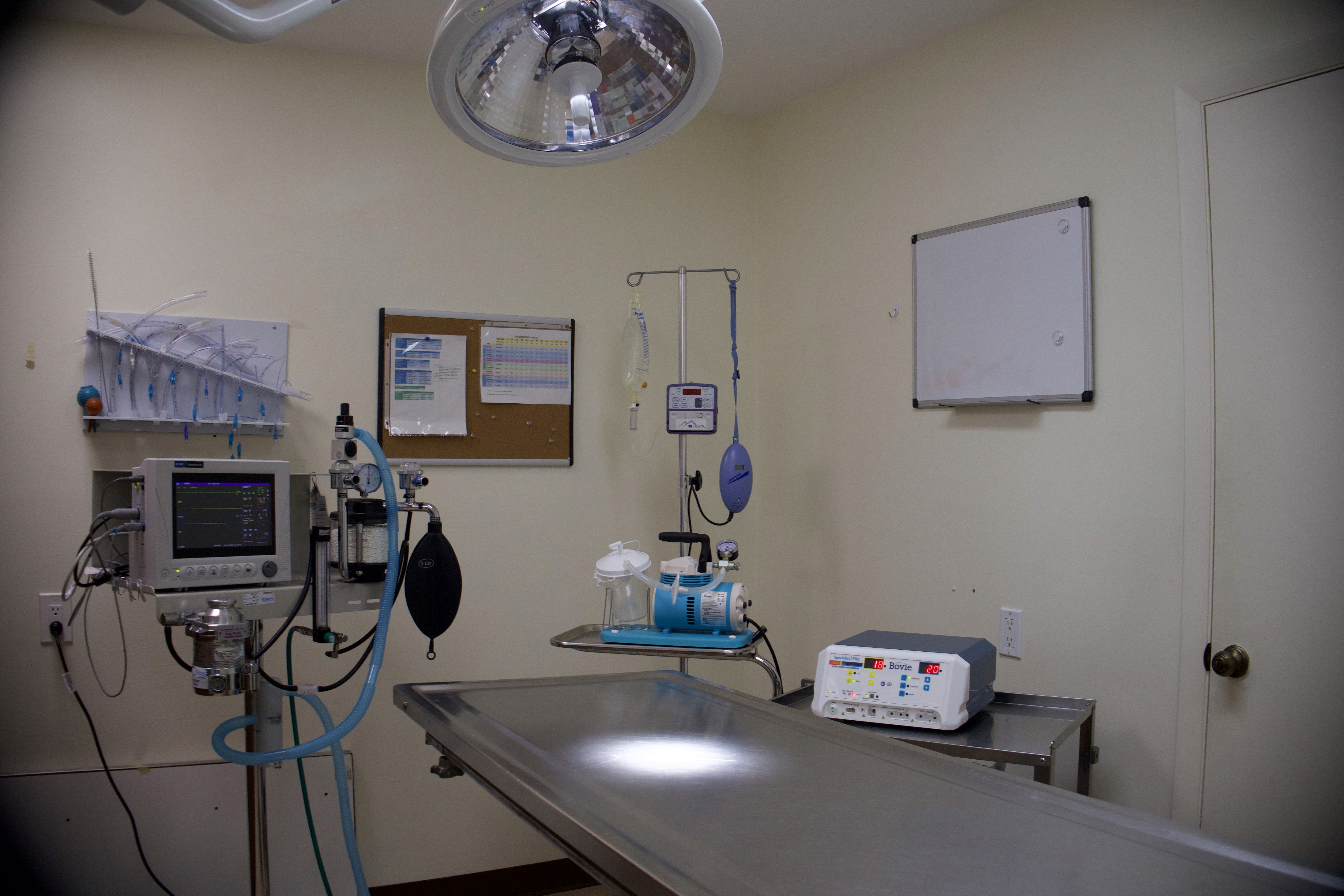 surgery room with surgery table, surgery light, and et tubes on the wall