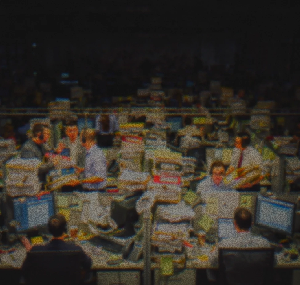 Busy trading floor with office workers at cluttered desks