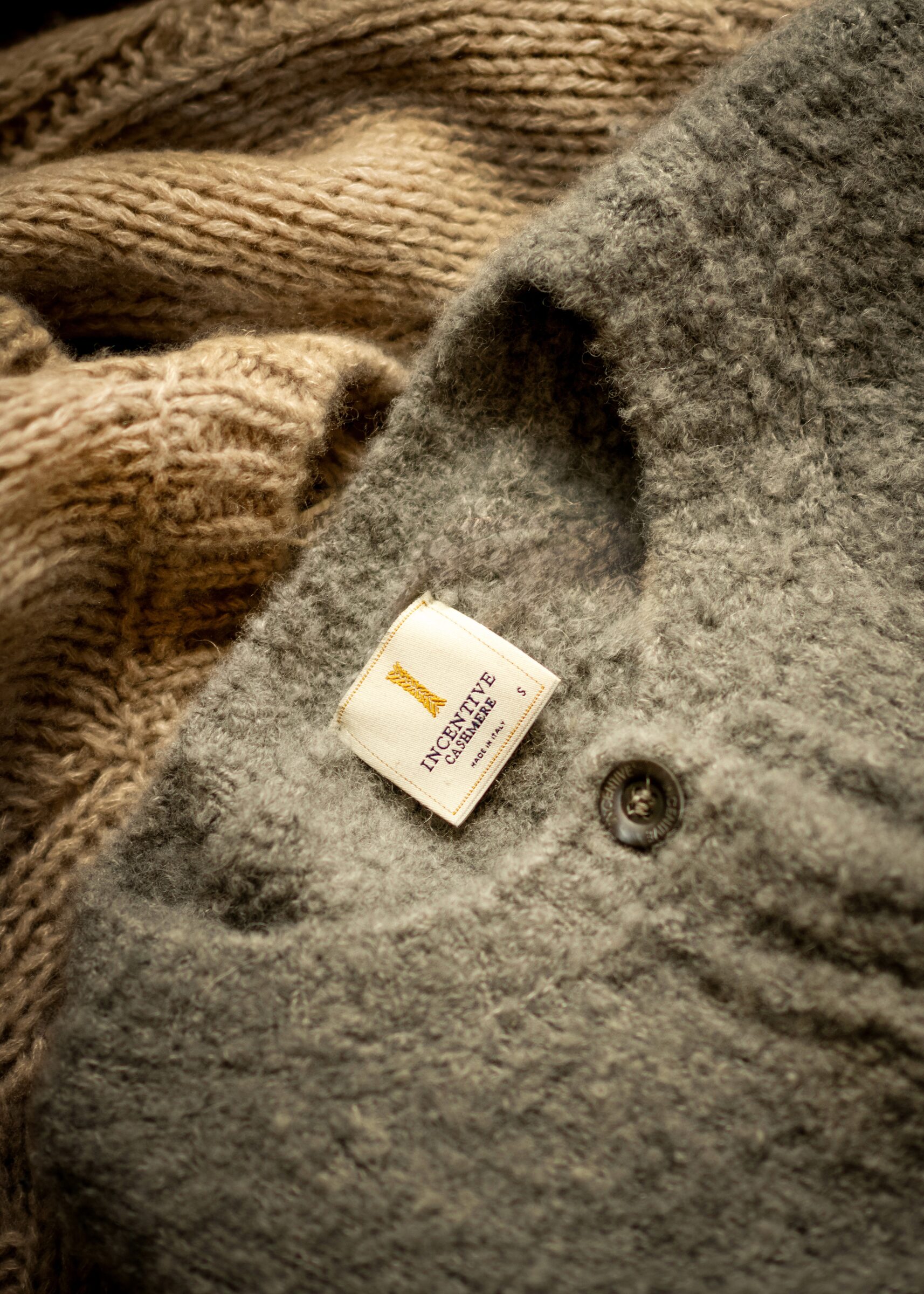 Kleiderstange mit Wildlederröcken und einem orangefarbenen Kaschmirpullover