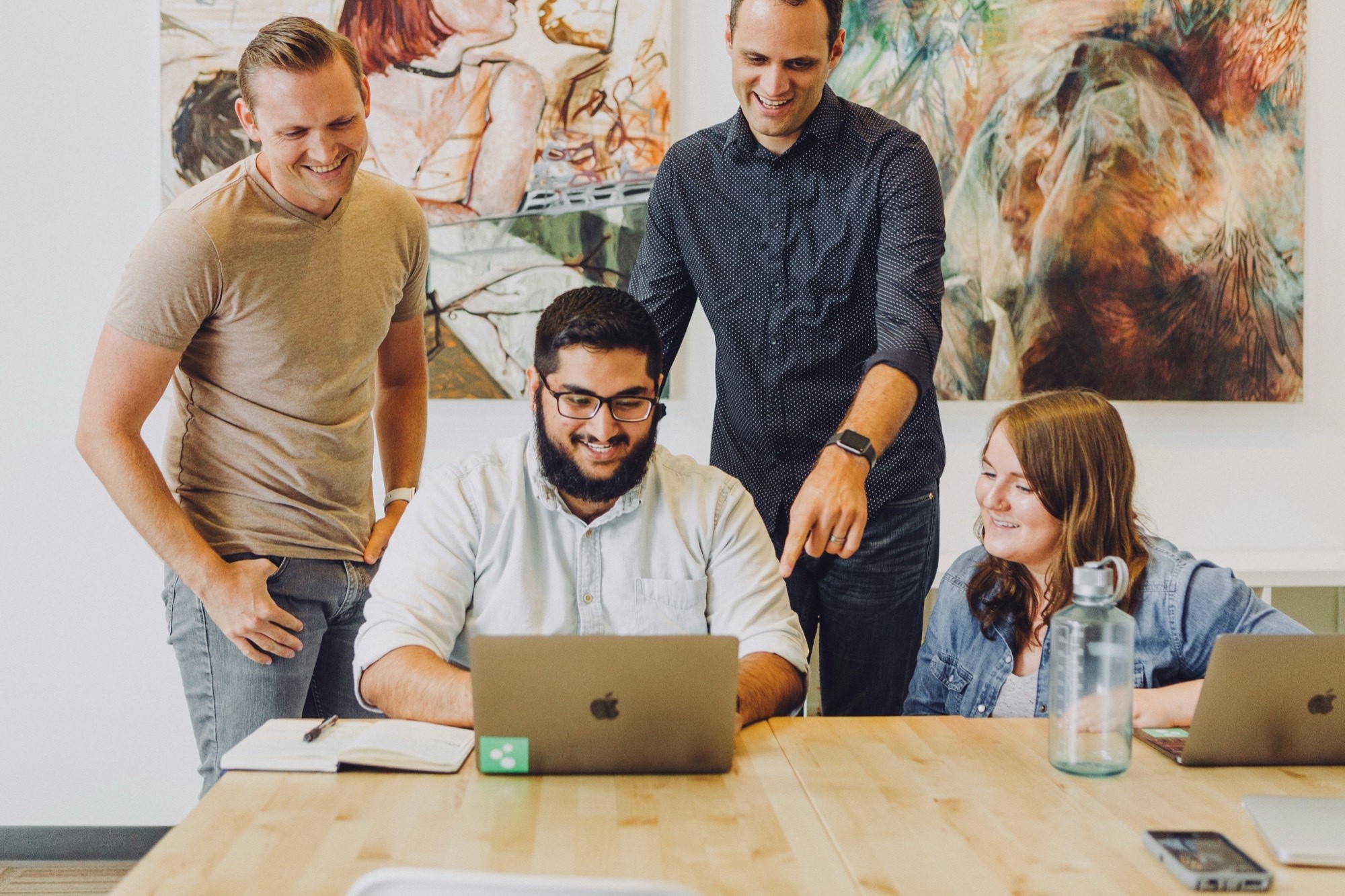 A team gathered around a laptop, working through a change together