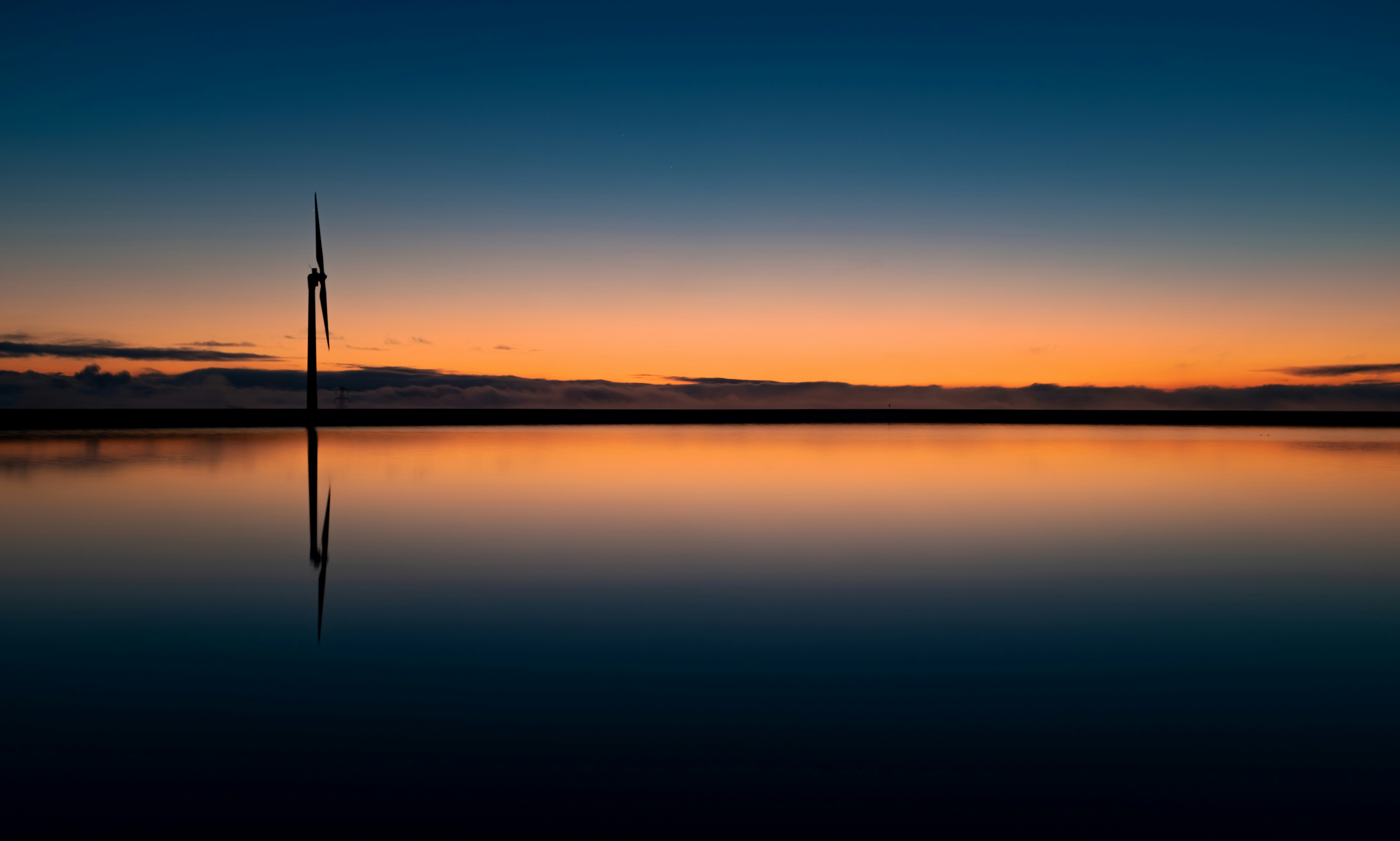 white wind turbine under blue sky during daytime