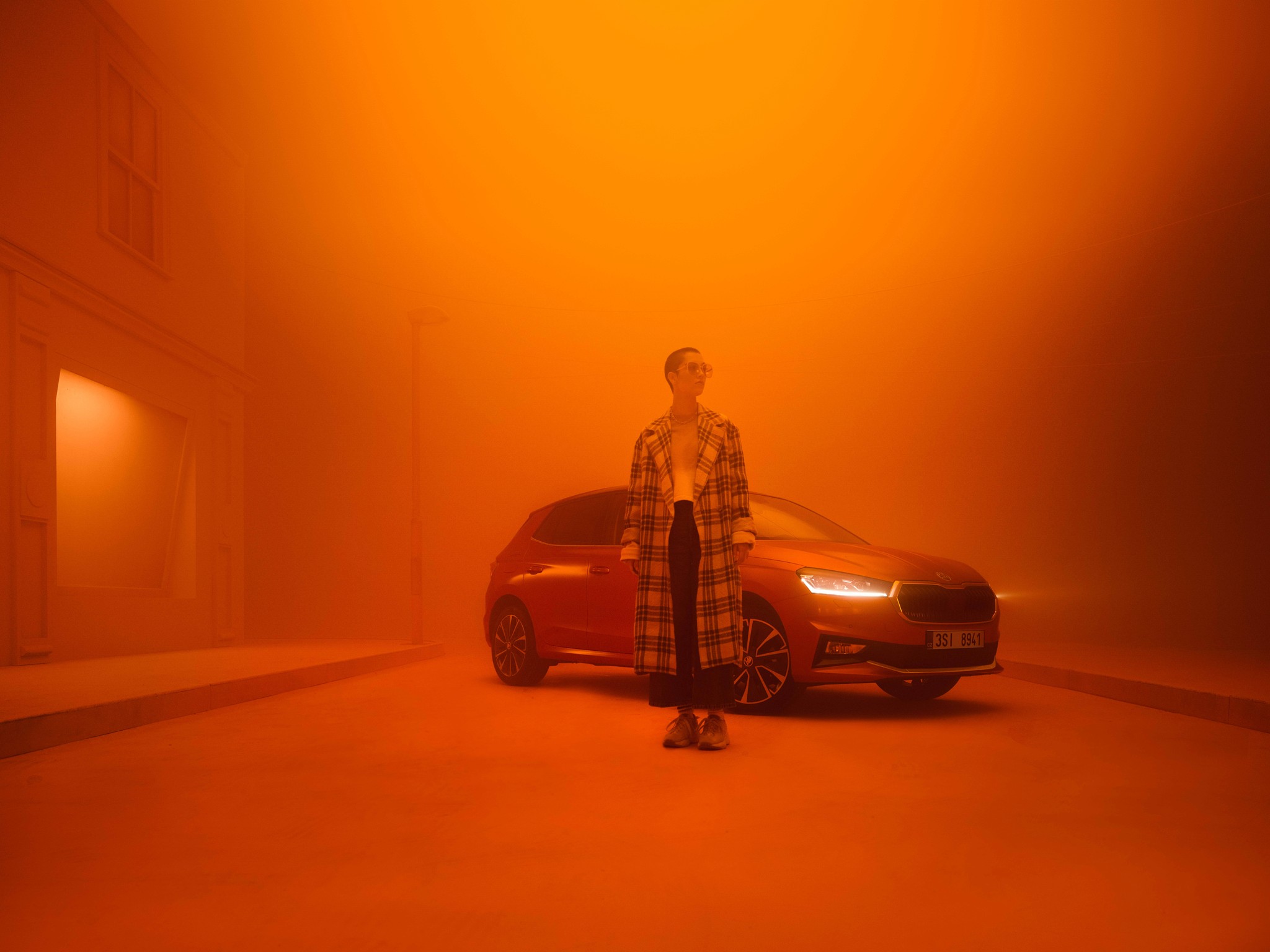 Kolja_Eckert_Skoda_Fabia_woman_standing_in_front_of_car_in_orange_haze