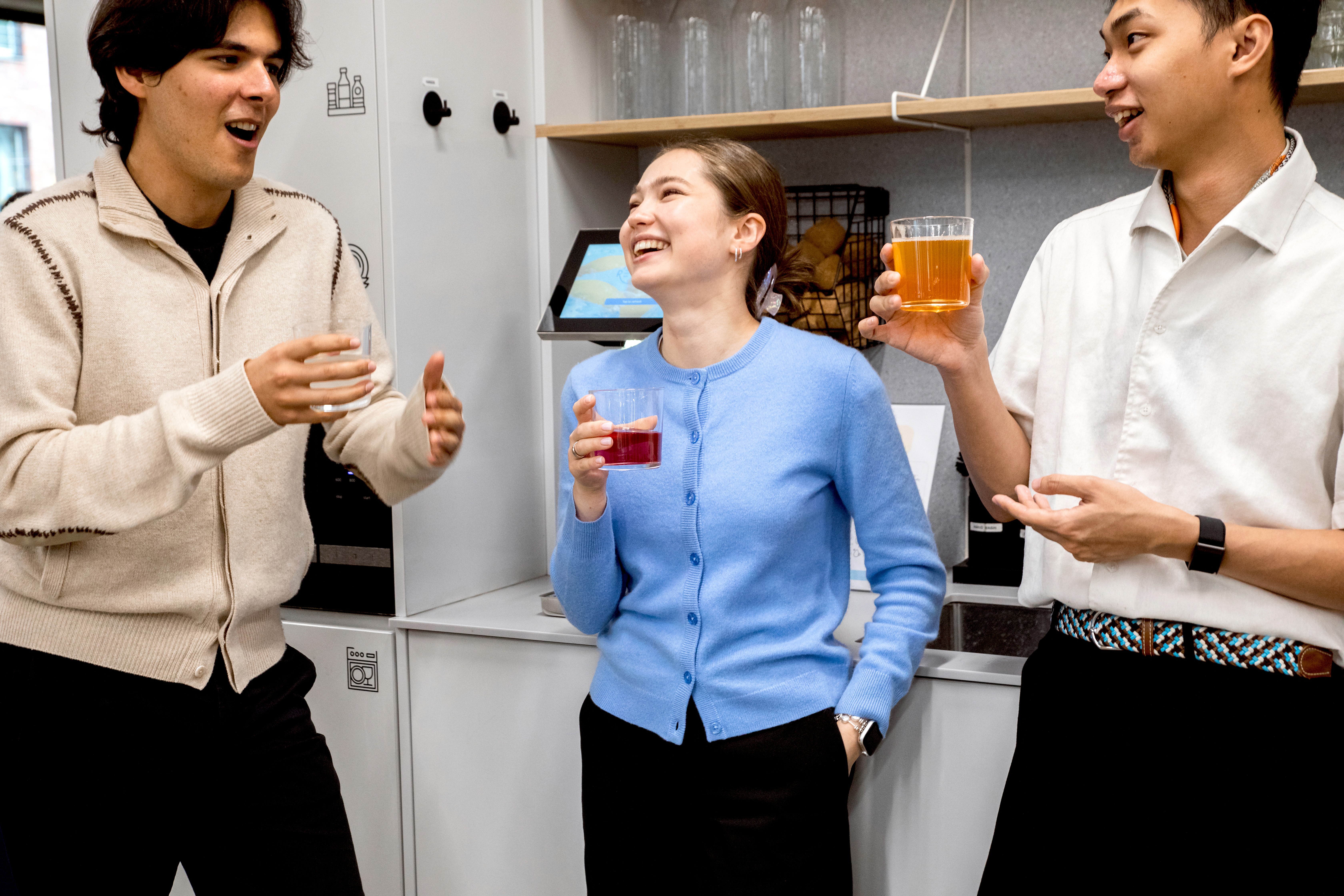 Team lacht in der mittagspause mit einem frischen getränk in der hand