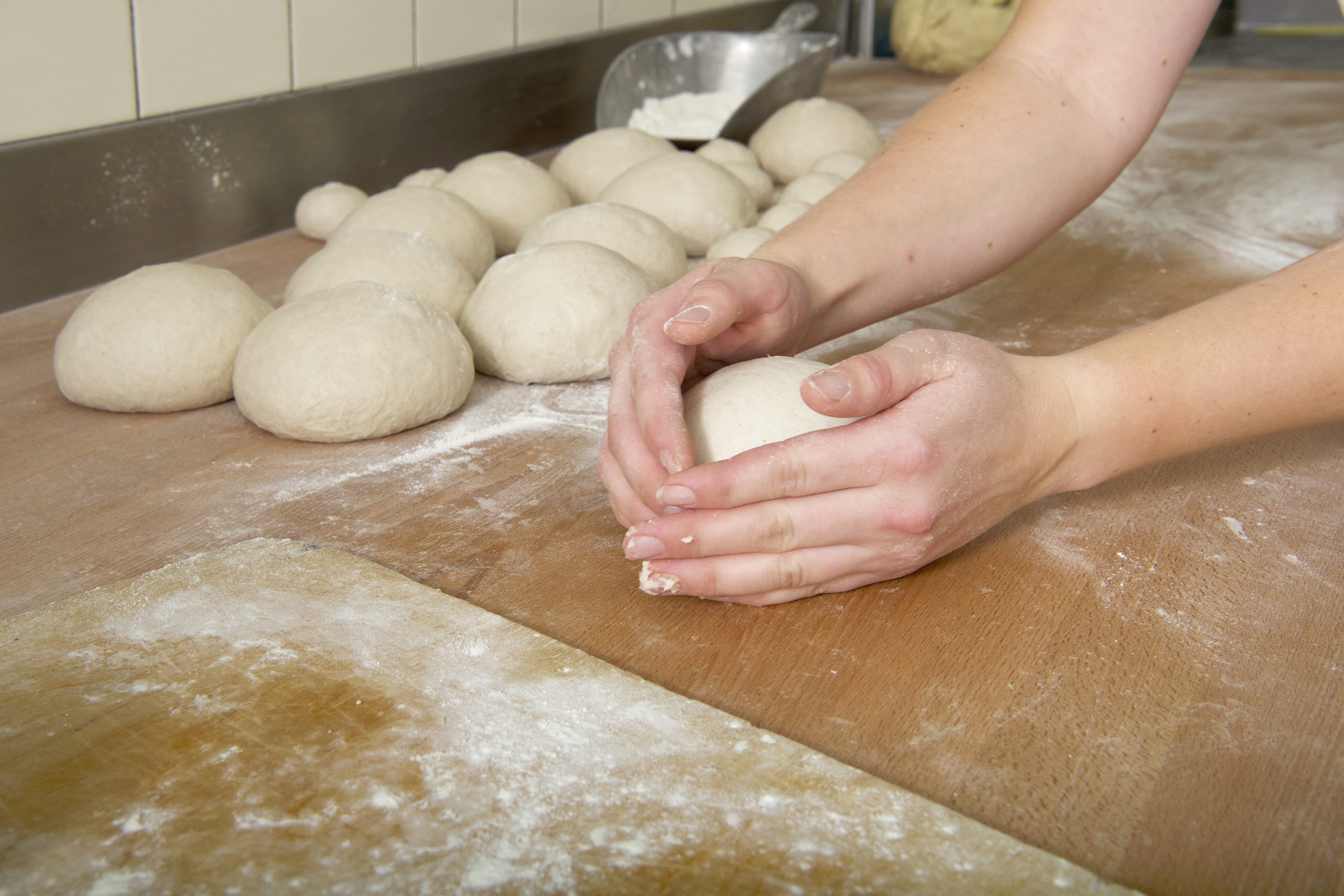 Hände formen Brotteig in der Bäckerei Hörnli Hemberg