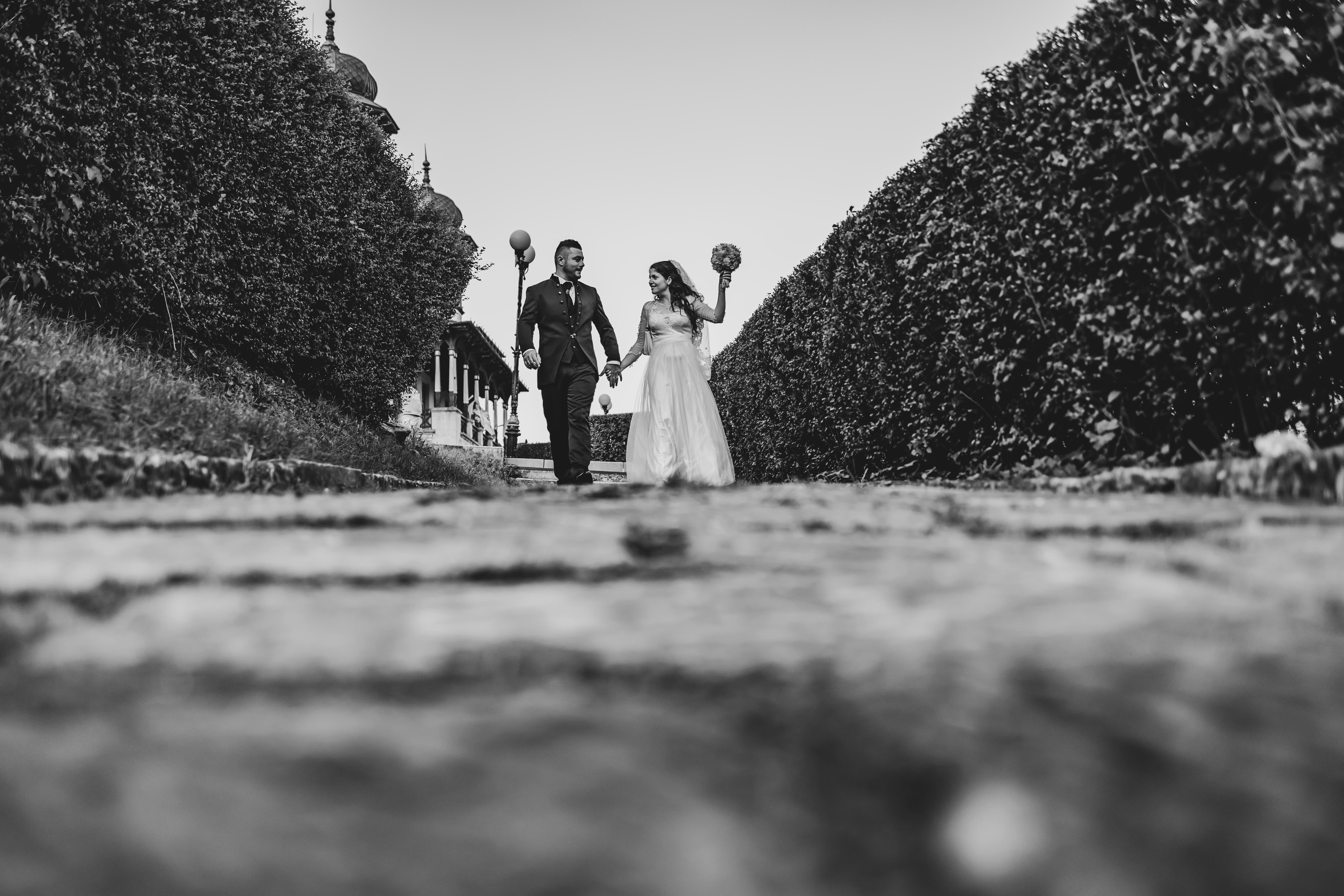 A couple joyfully celebrates in front of a rustic stone building.
