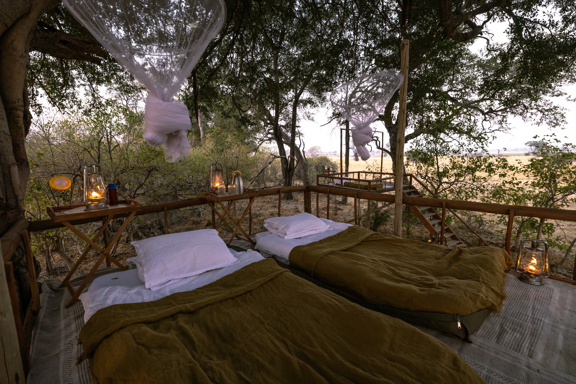 Kujwana Delta Ride, Okavango Delta, Botswana – ridsemester i Afrika med två sängar bredvid varandra på upphöjd plattform under bar stjärnhimmel, mitt i vildmarken på ridsafari. Myggnät omger plattformen