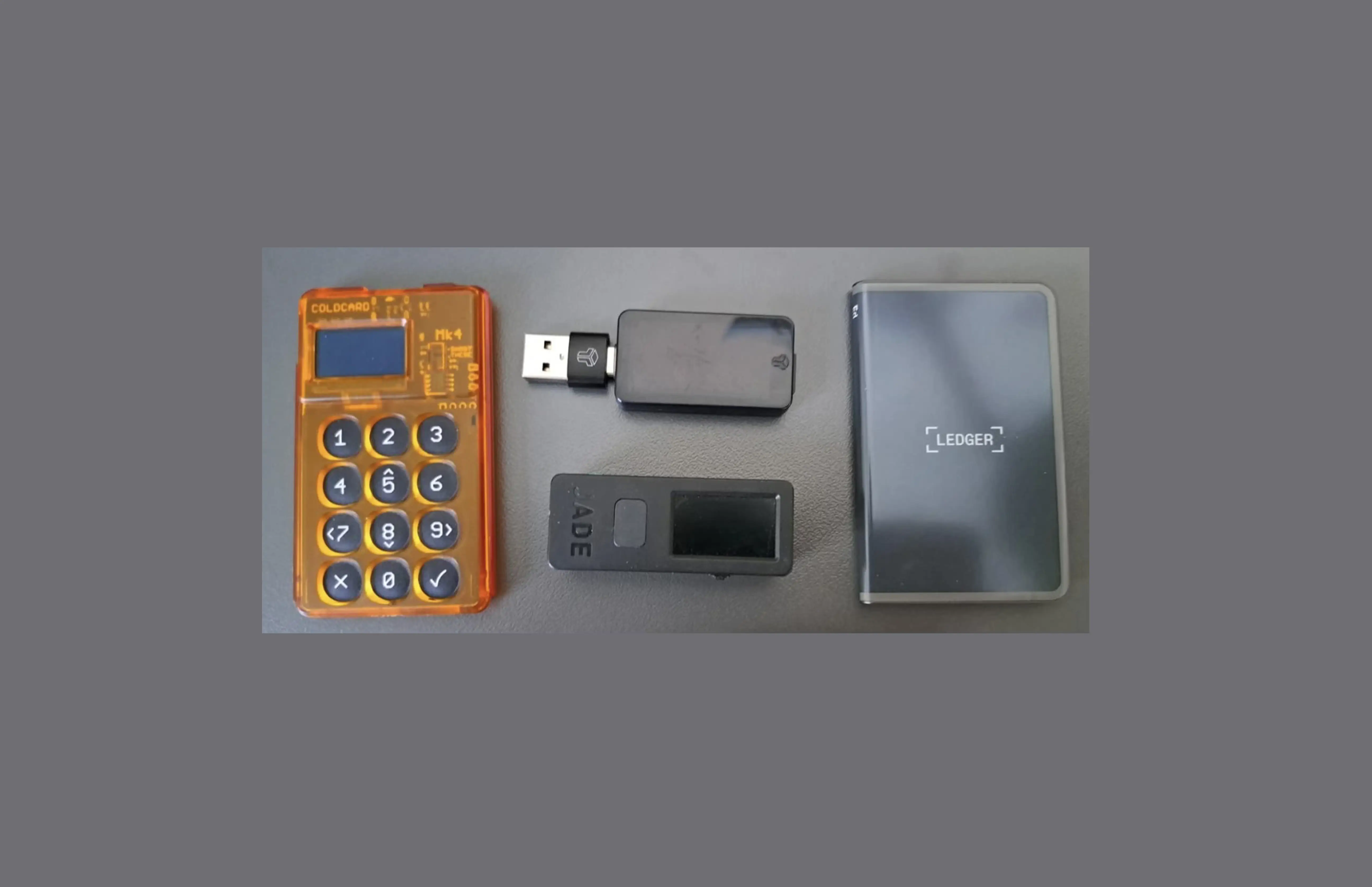 Side-by-side photo of a Coldcard hardware wallet and a Ledger hardware wallet, the two device families whose different security architectures are compared throughout this article.