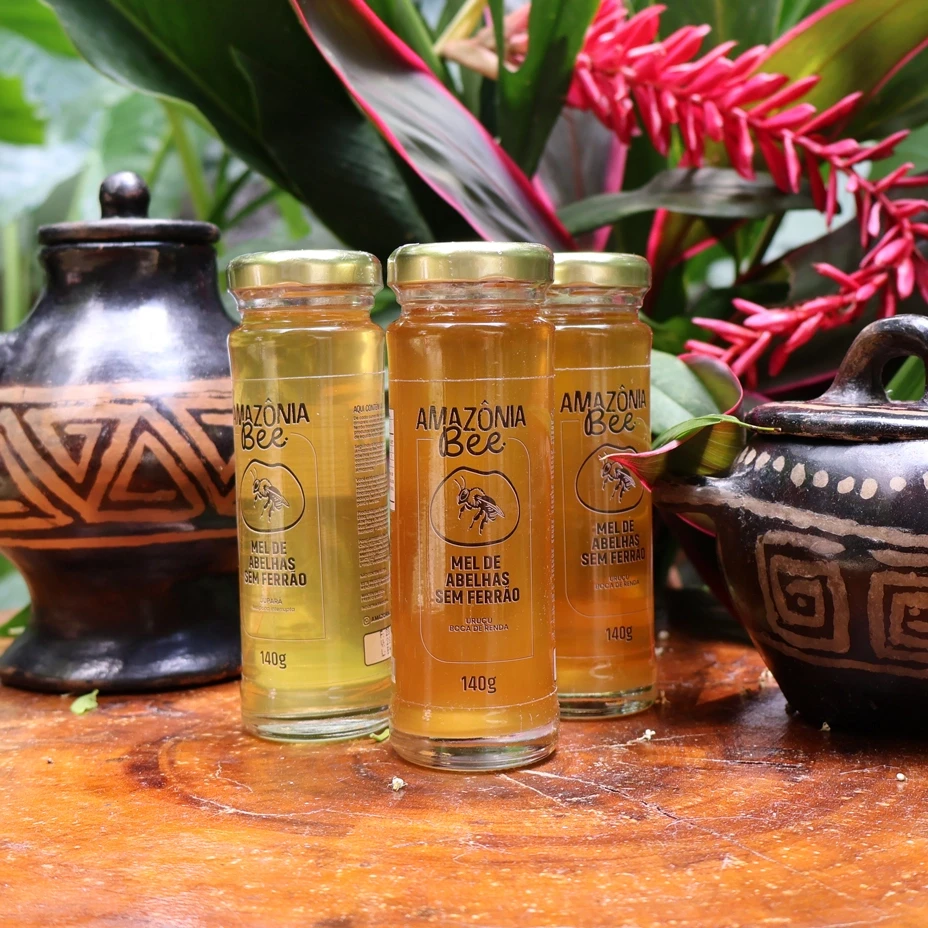 Garrafas de mel de abelhas sem ferrão em fundo amazônico.