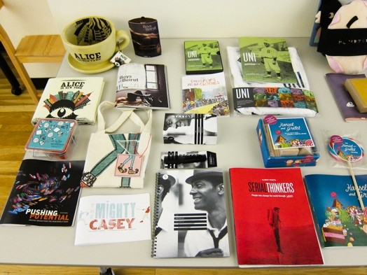 a table full of booklets and flyers and miscellaneous merchandise