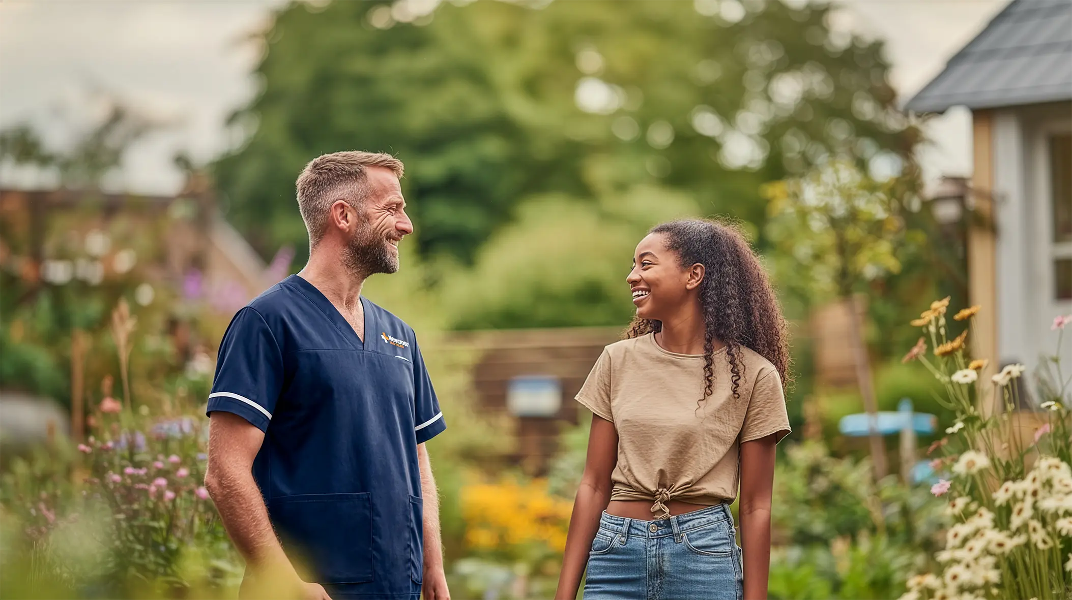 Newcross care worker talking with teenager in garden at children's residential home